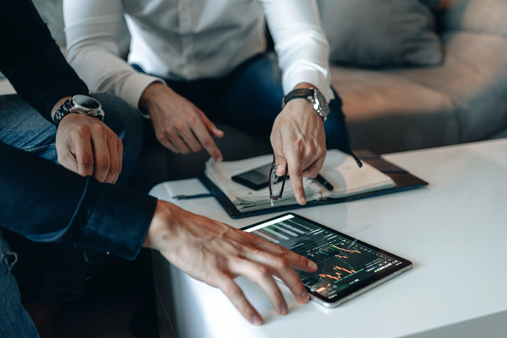 People reviewing financial or business information on a tablet.