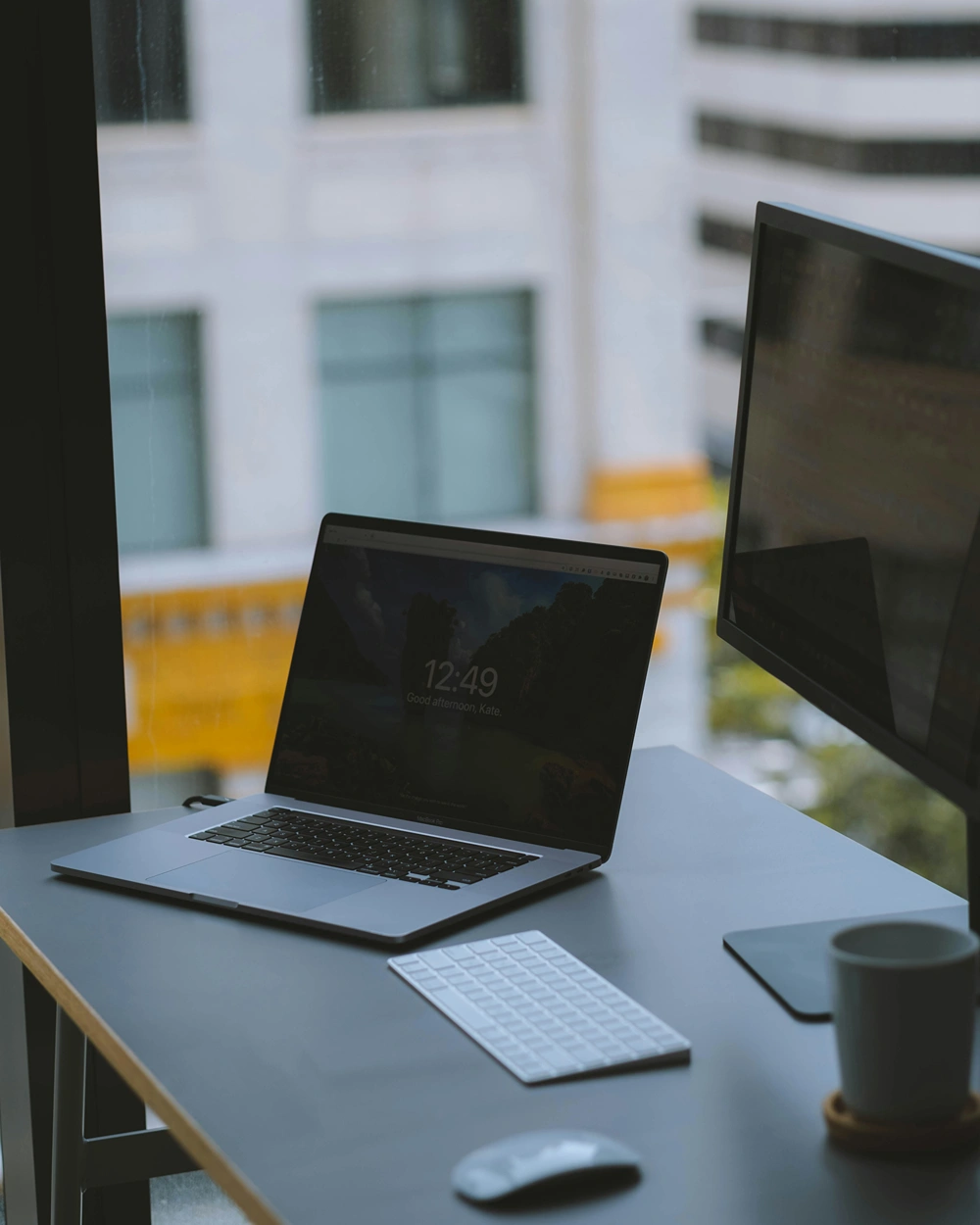 Laptop and desktop monitor on a modern office desk.