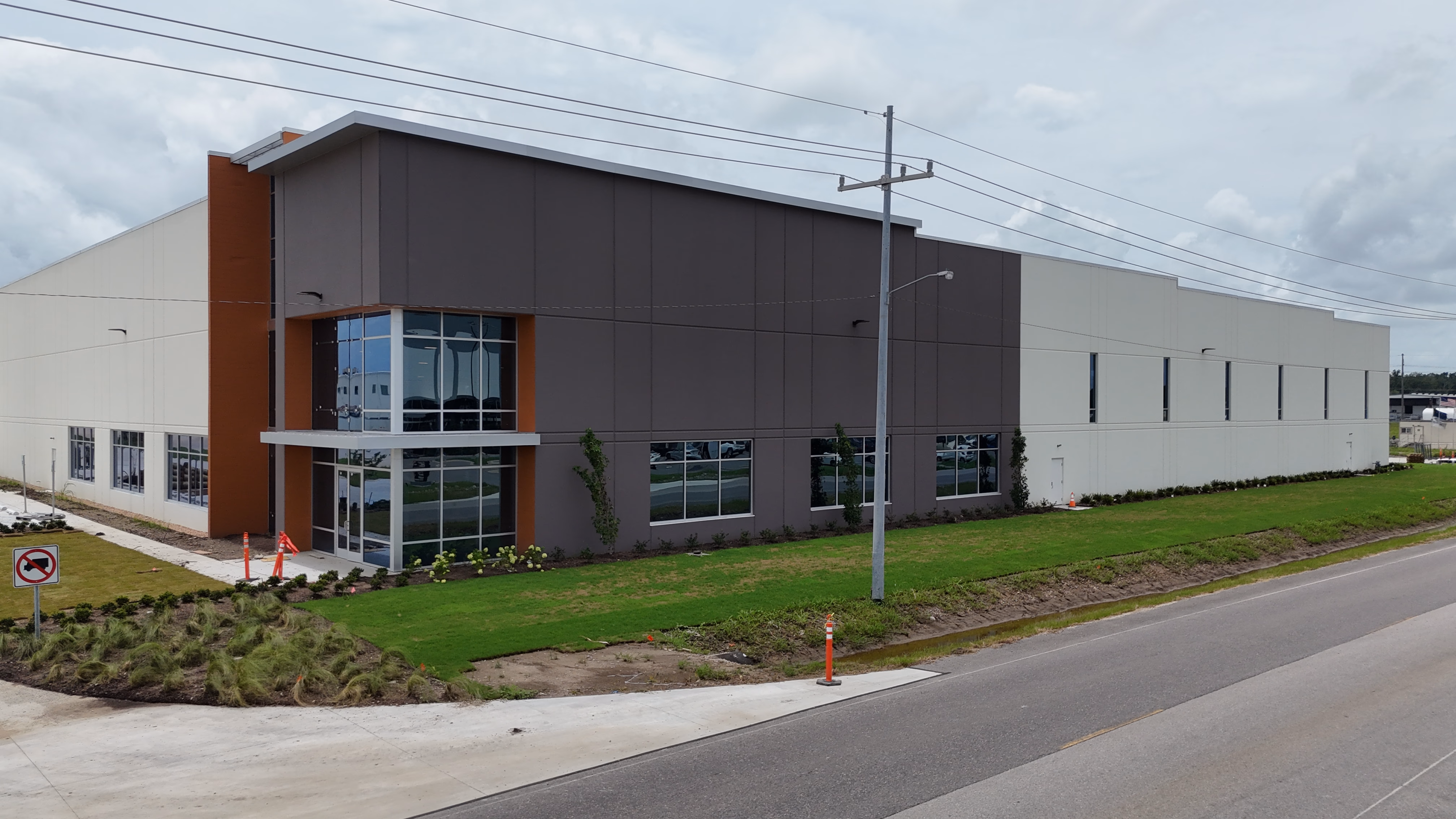 Modern commercial building with a gray exterior and large entrance windows.