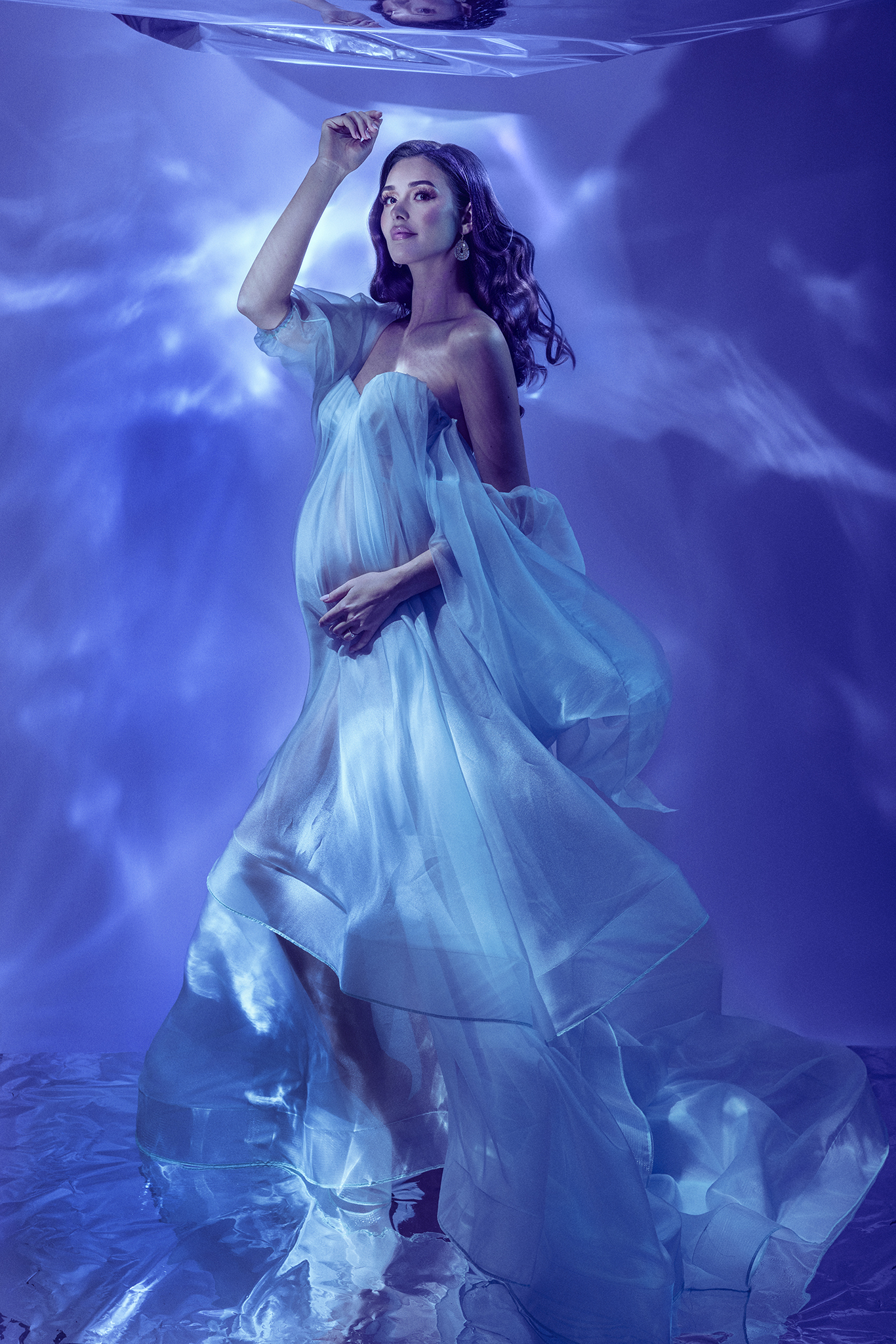 OPERA by Claudia Spaziani – servizio premaman irripetibile a Bologna: ritratto con abito organza azzurro, maniche a sbuffo e proiezioni luminose blu, set scenografico costruito da zero per una sola persona