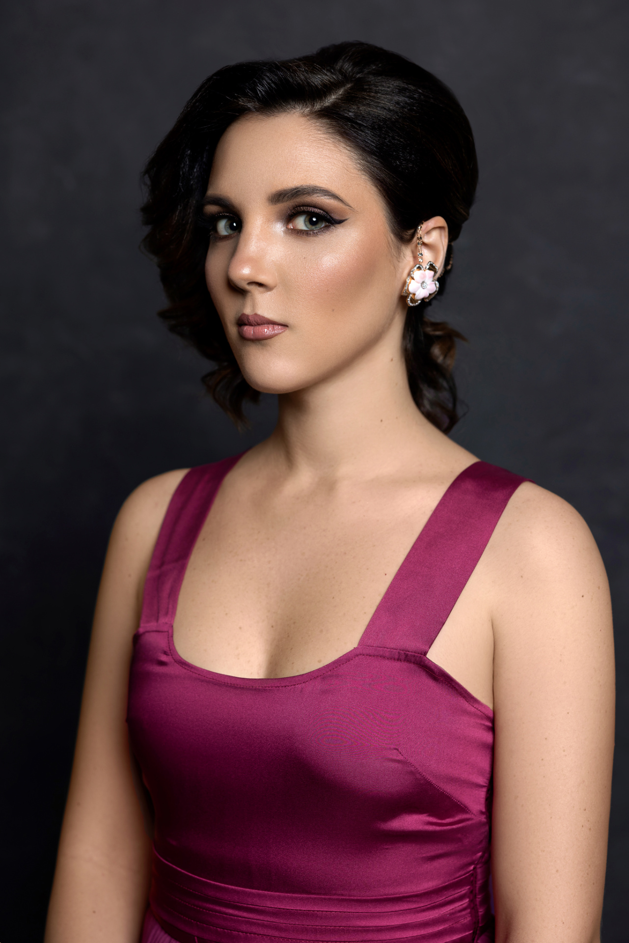 Fiametta, cantante lirica, in abito bordeaux plissé con trucco drammatico, ritratto glamour per book professionale di Claudia Spaziani nel suo studio a Bologna.