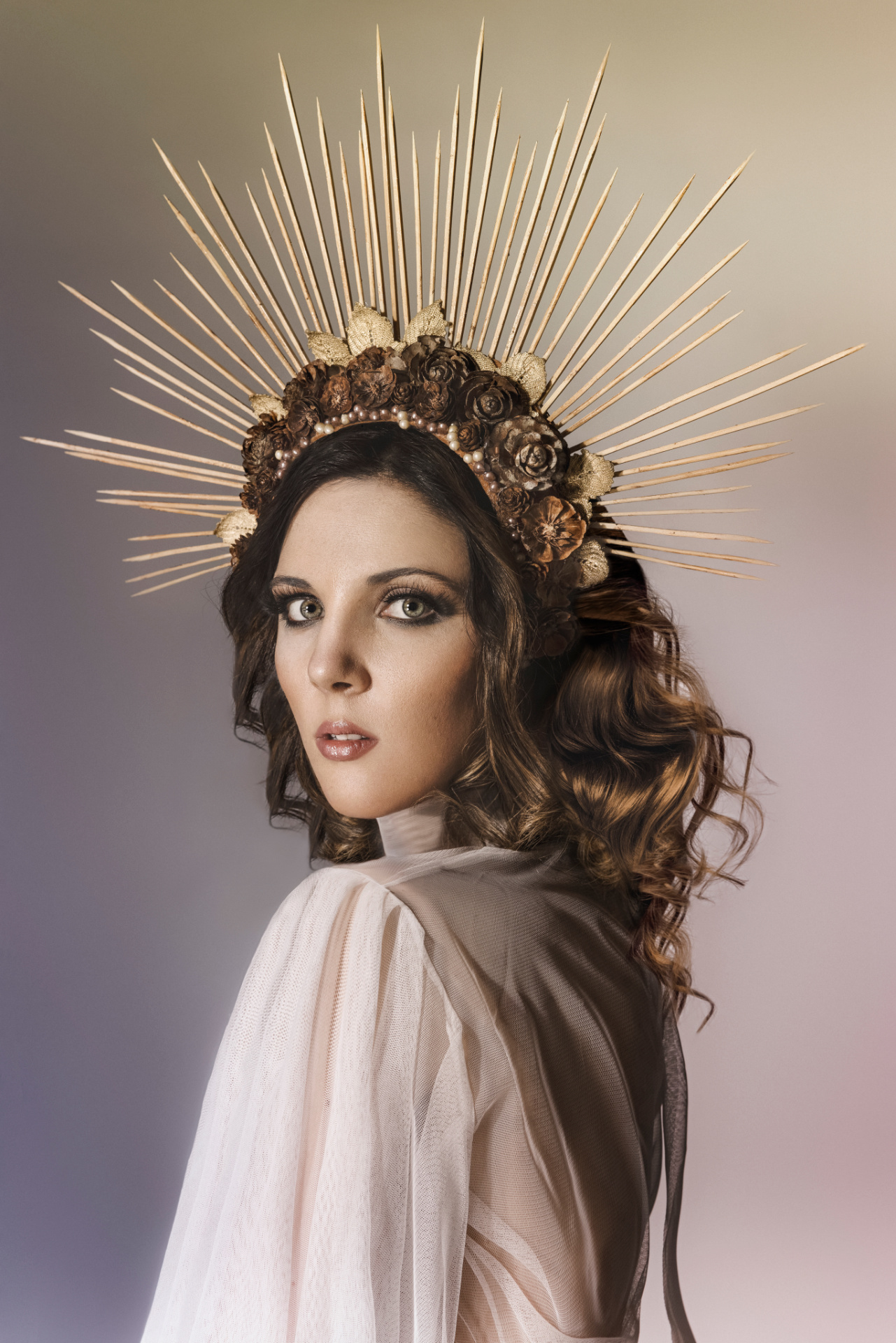 Cantante lirica con corona dorata a raggi e abito bianco etéreo, ritratto fine art sacrale per book professionale di Claudia Spaziani a Bologna.