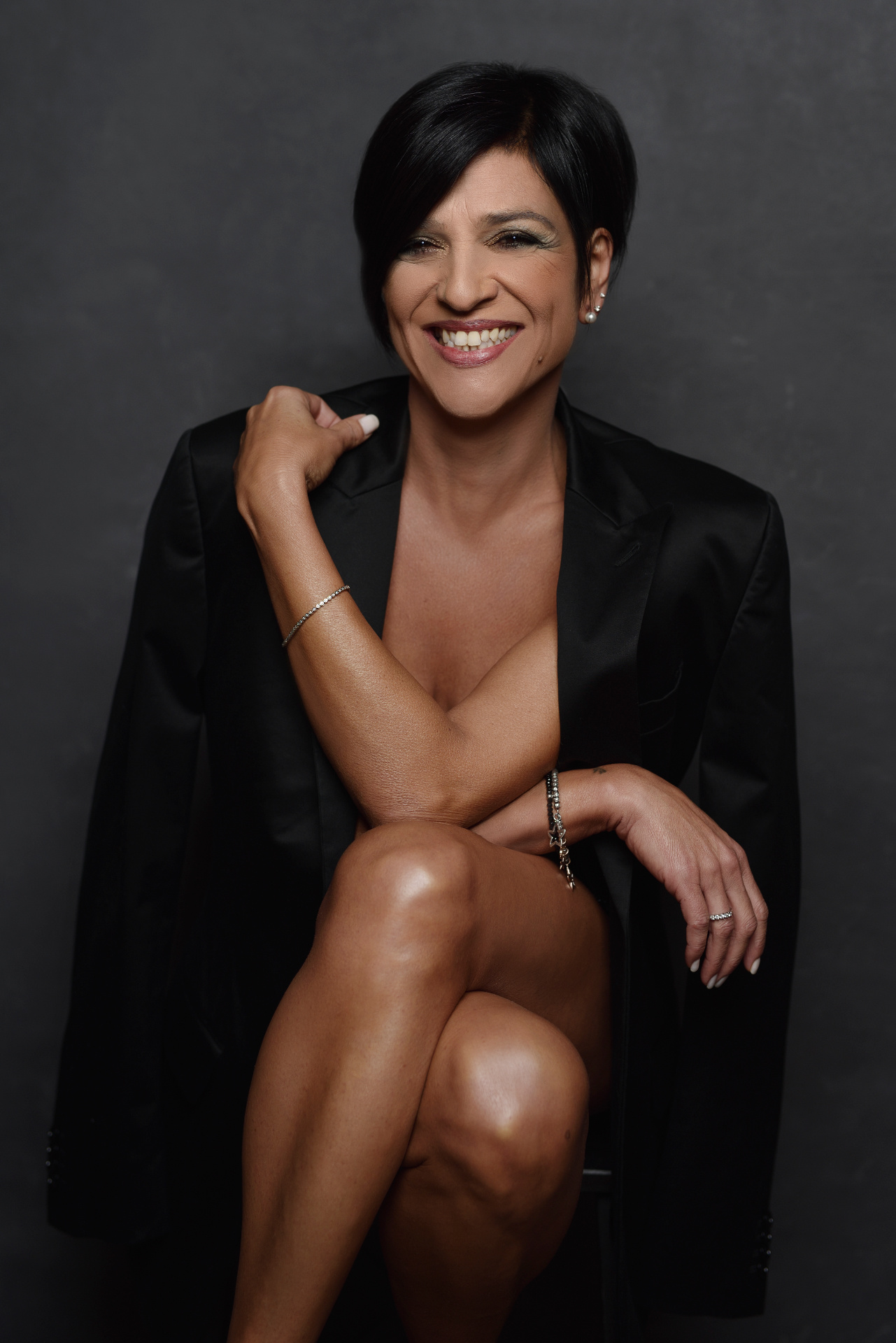 Ritratto creativo in studio scattato da Claudia Spaziani, fotografa fine art italiana; sorriso espressivo, blazer nero sulle spalle e illuminazione morbida e professionale.