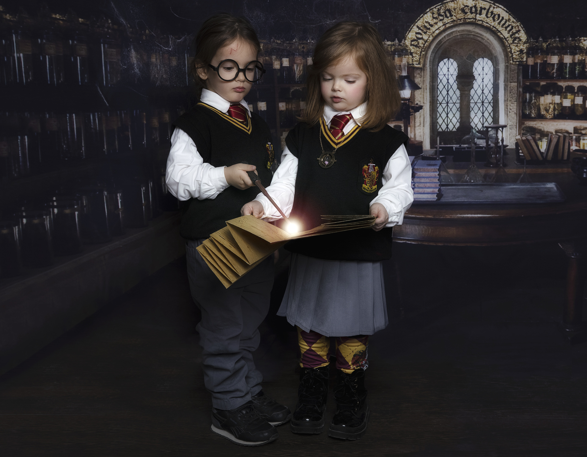 Ritratto narrativo con bambini in uniforme e sciarpa che lanciano incantesimi su un libro magico.