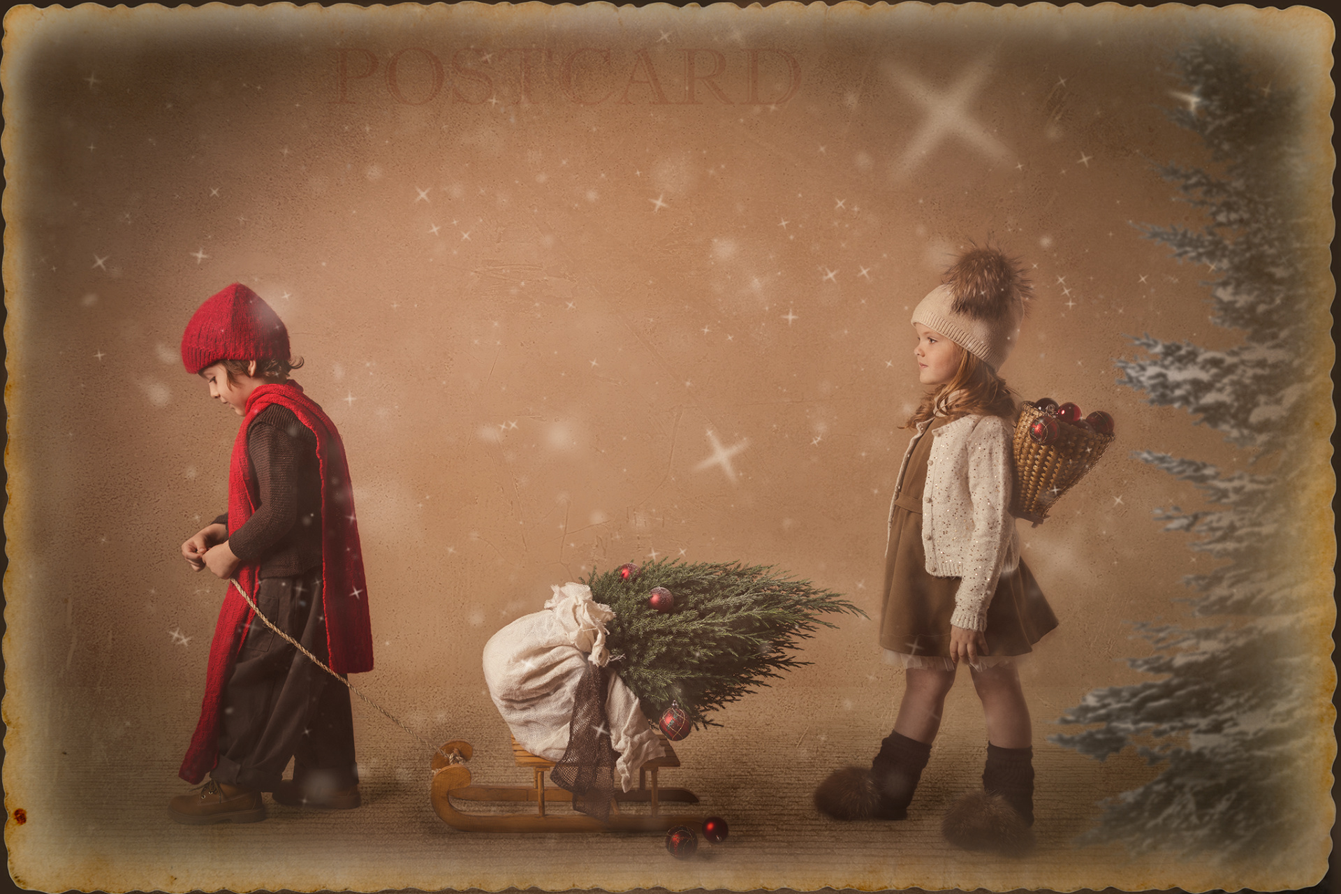 Cartolina fotografica vintage con due bambini in abiti invernali, slitta e decorazioni natalizie, scattata da Claudia Spaziani.