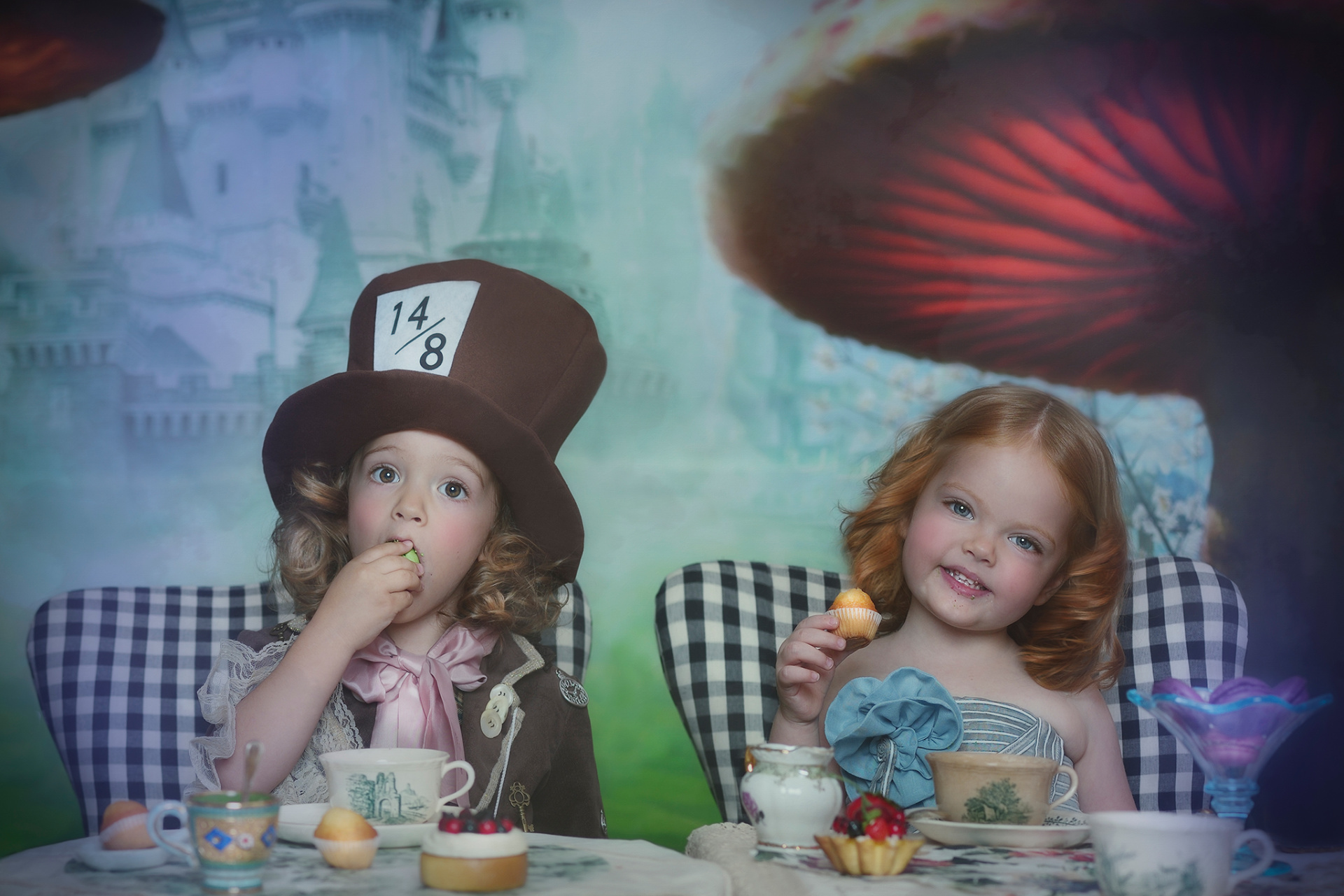 Bambini in posa teatrale con abiti da fiaba e sfondo con castello e funghi giganti, ritratti da Claudia Spaziani.
