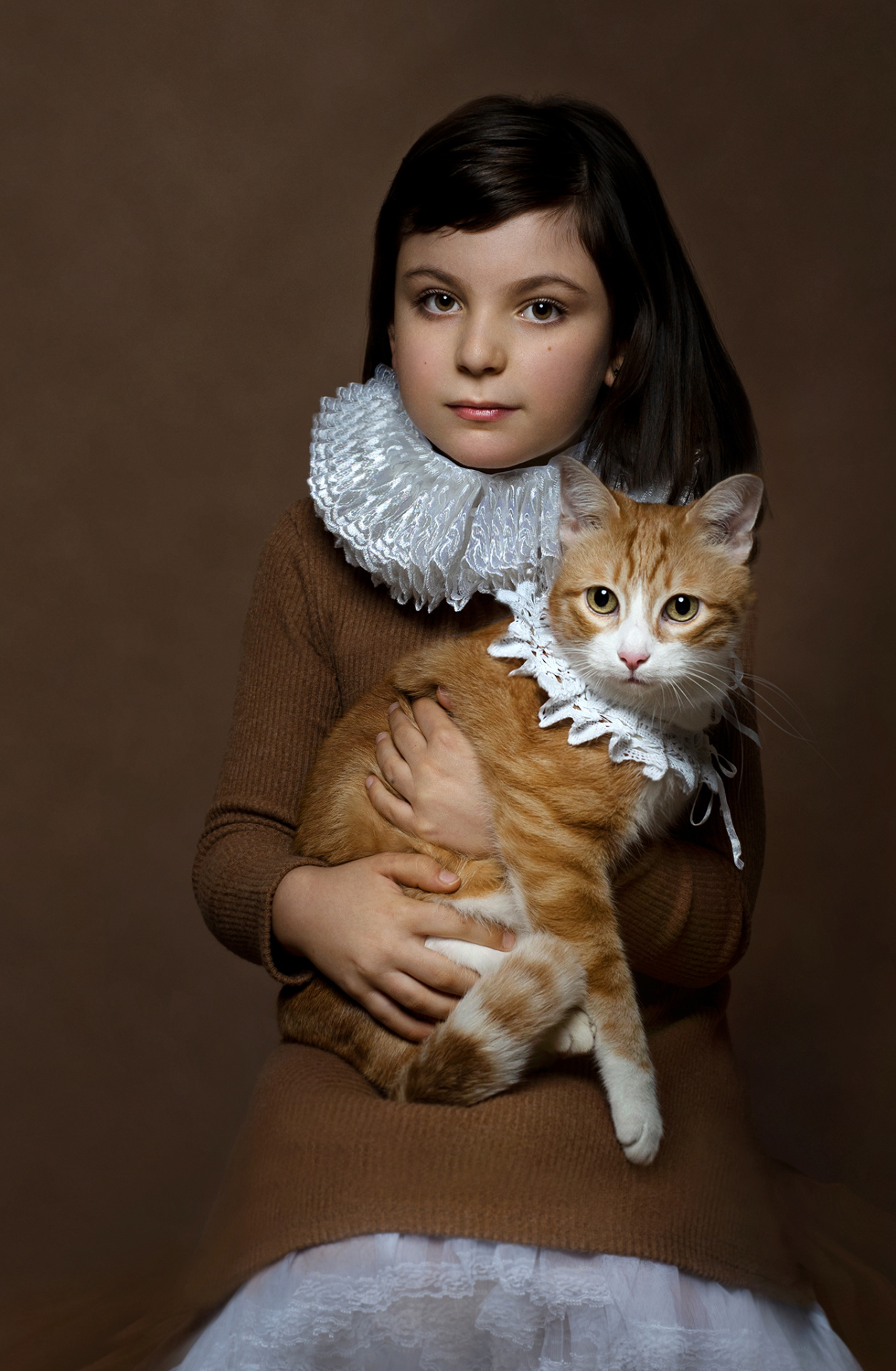 itratto fine-art di bambina con gatto in abiti rinascimentali, su sfondo marrone, scattato da Claudia Spaziani nel suo studio fotografico a Bologna.