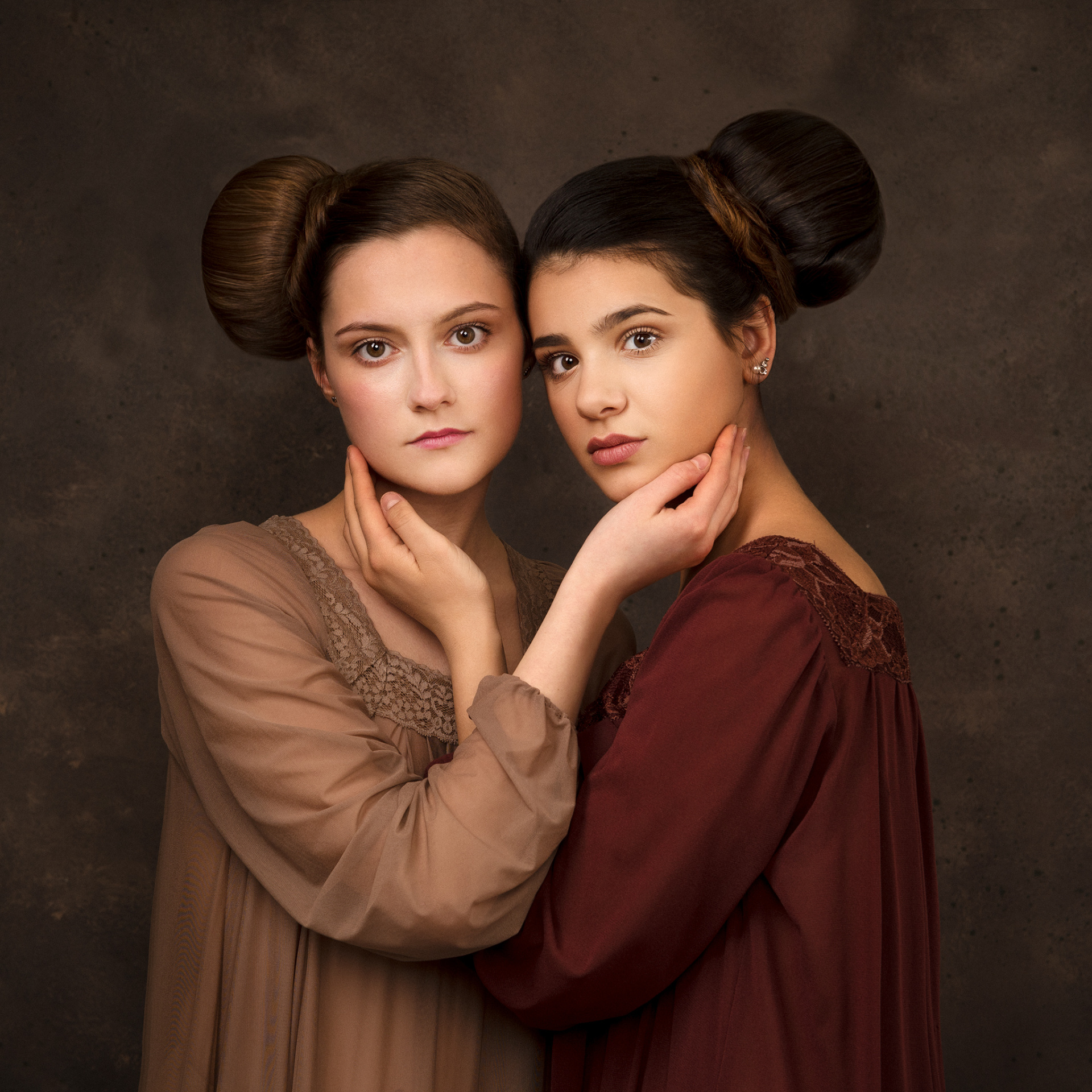 Ritratto classico di due adolescenti in abiti lunghi con dettagli in pizzo, in posa simmetrica, realizzato da Claudia Spaziani nel suo studio fotografico a Bologna.