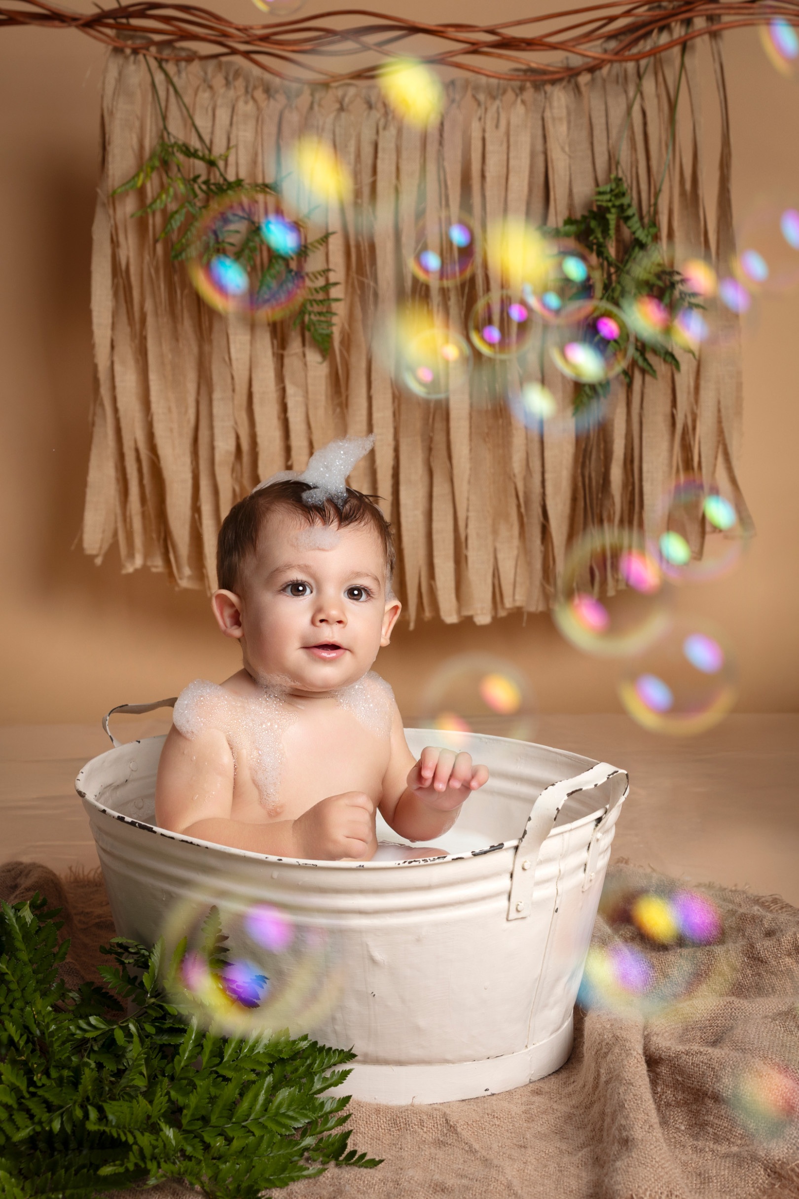 Bambino nella vasca circondato da bolle di sapone colorate — sessione splash boho di Claudia Spaziani, Bologna.