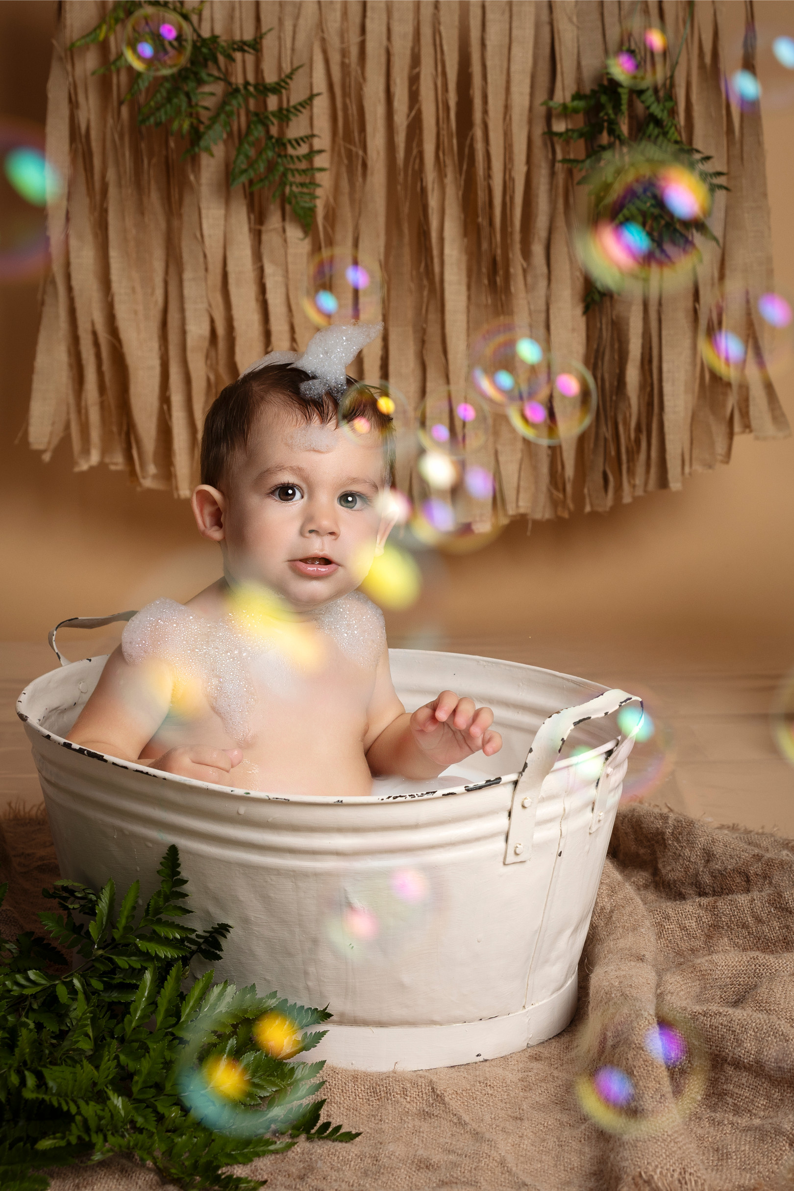 Bambino nella vasca tra schiuma e bolle di sapone — set splash boho naturale a Bologna.