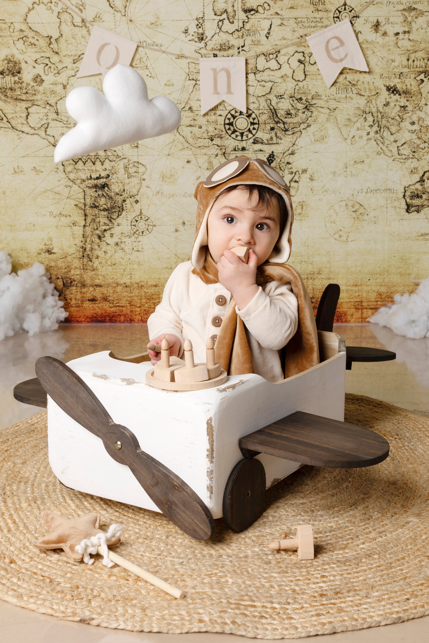 Primo piano del bambino con cappello e occhiali da aviatore nell’aeroplanino di legno — set a tema esplorazione, Bologna.