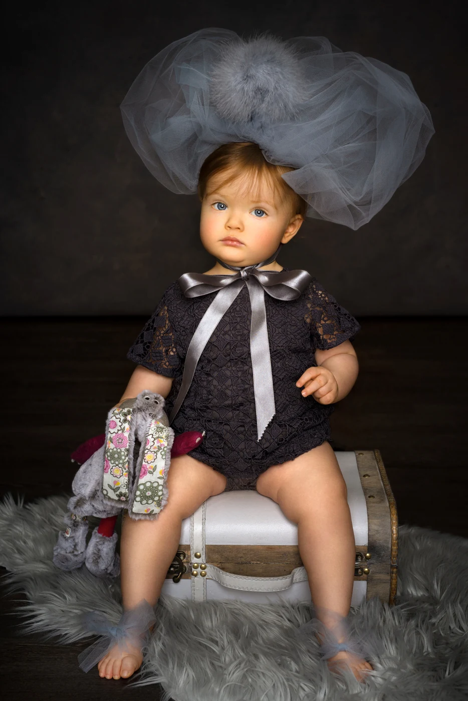 Ritratto artistico di bambina con copricapo in tulle grigio e fiocco satinato, studio fotografico a Bologna — Claudia Spaziani.