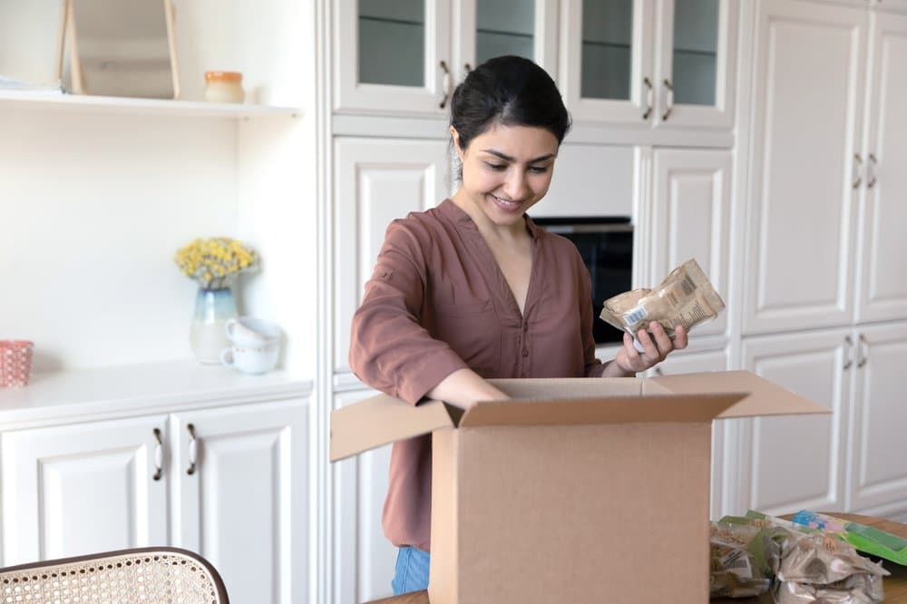 Person unpacking a grocery delivery box at home