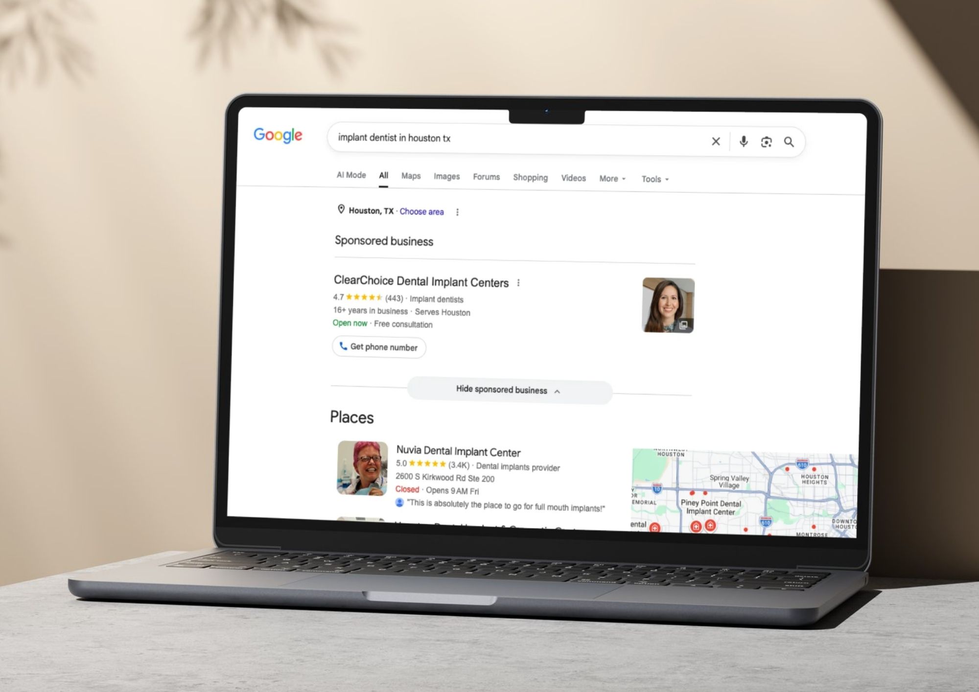Laptop screen showing Google search results for 'implant dentist in houston tx' with sponsored ClearChoice Dental Implant Centers listing and Places section including Nuvia Dental Implant Center details and map of nearby locations.