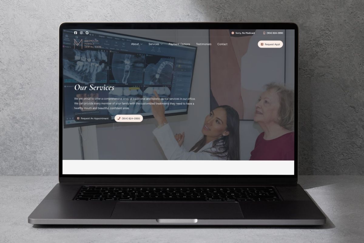 Laptop displaying Magnolia Family Dental Care website's services page with a female dentist showing dental X-rays on a screen to an elderly woman.