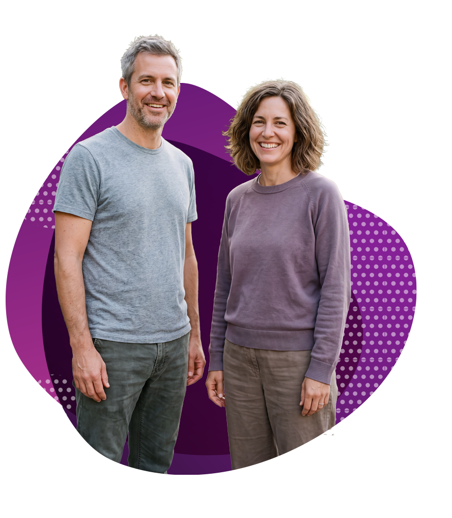 Smiling man in gray t-shirt and woman in purple sweatshirt standing against purple dotted background.