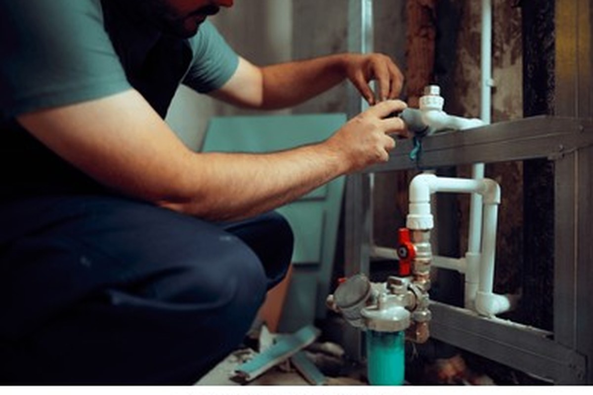 Plumber servicing a garbage disposal under a kitchen sink in Coon Rapids, MN