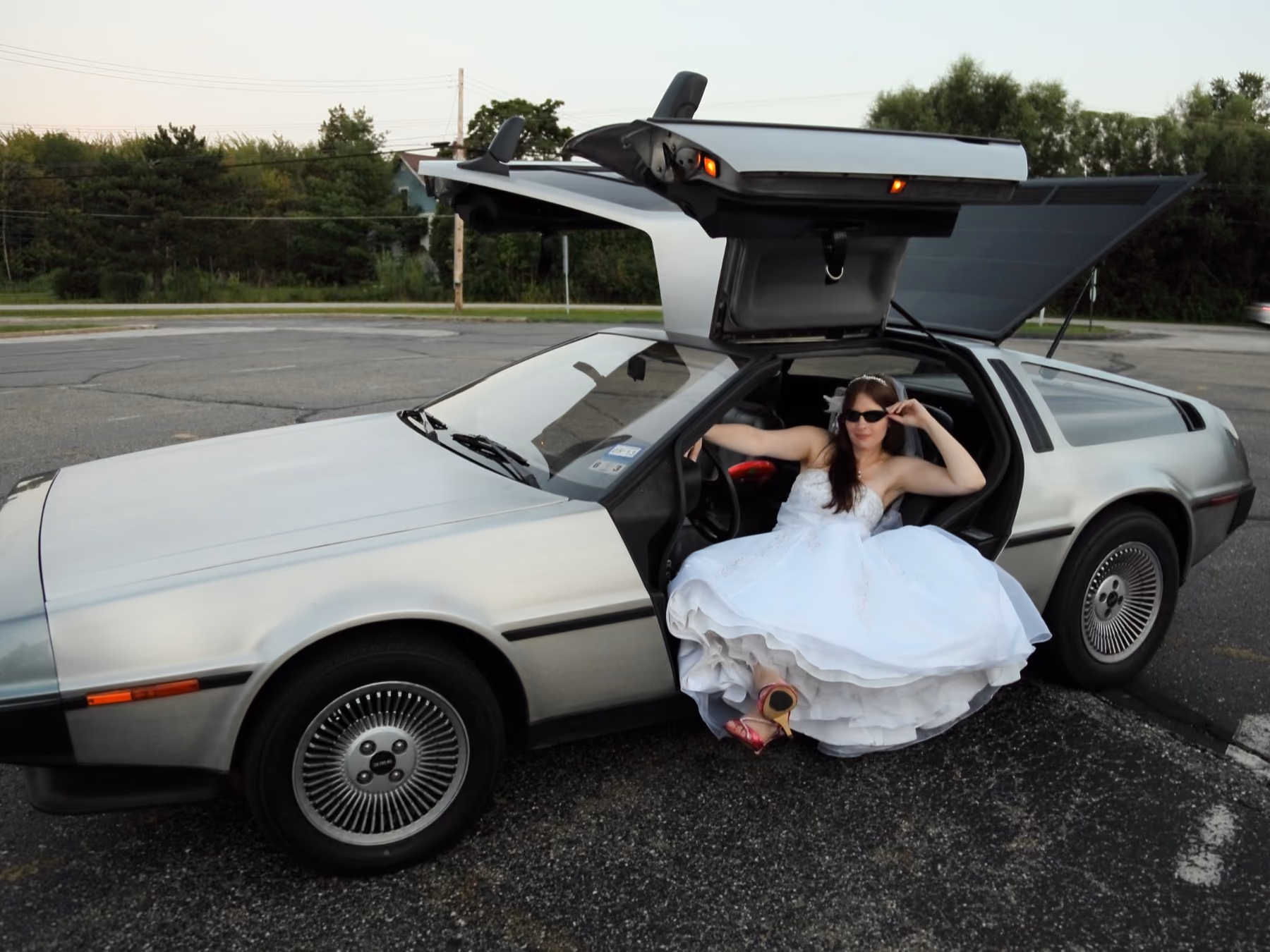Bride posing with a DeLorean by Fullerton Photography