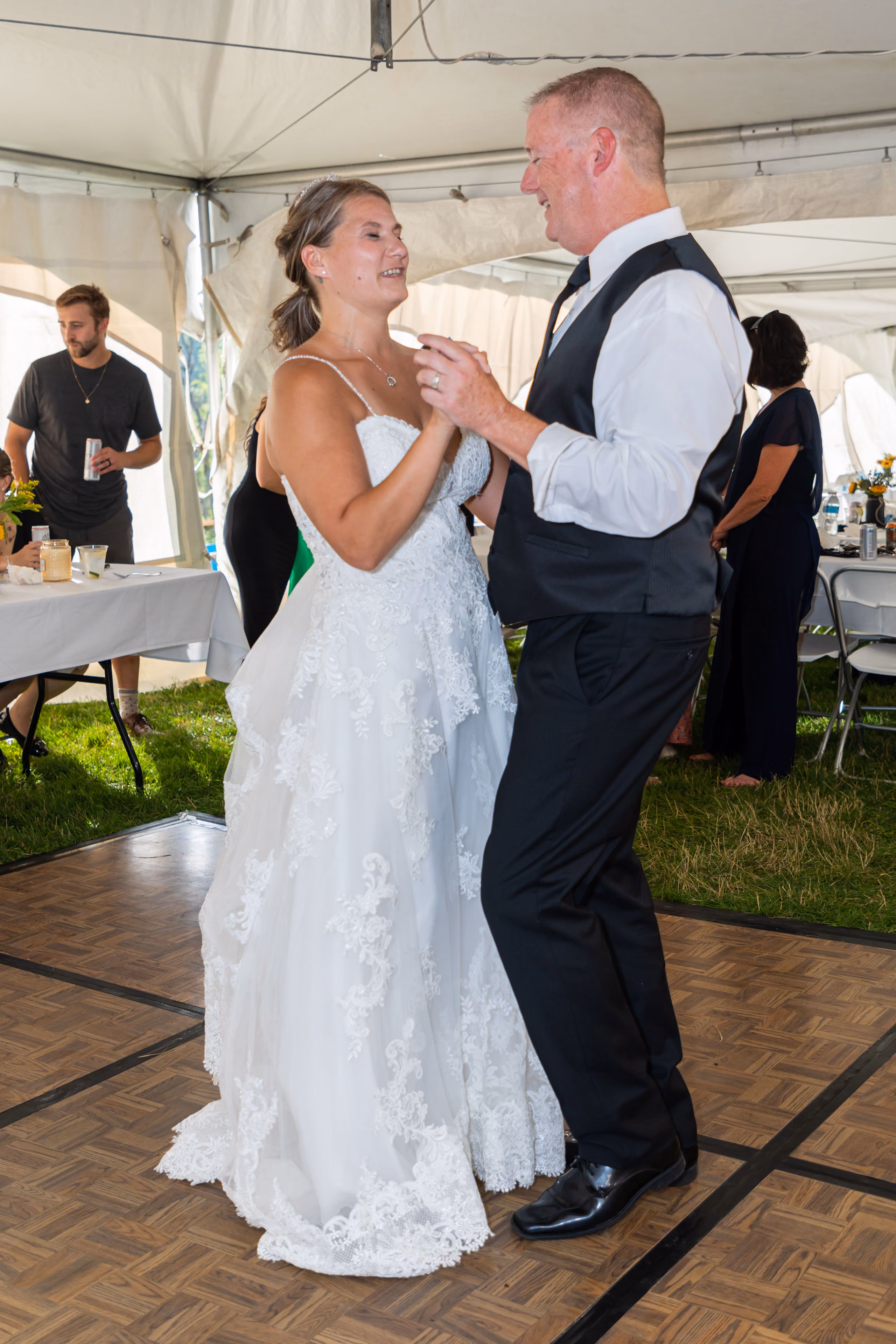Bride and groom sharing their first dance under a reception tent
