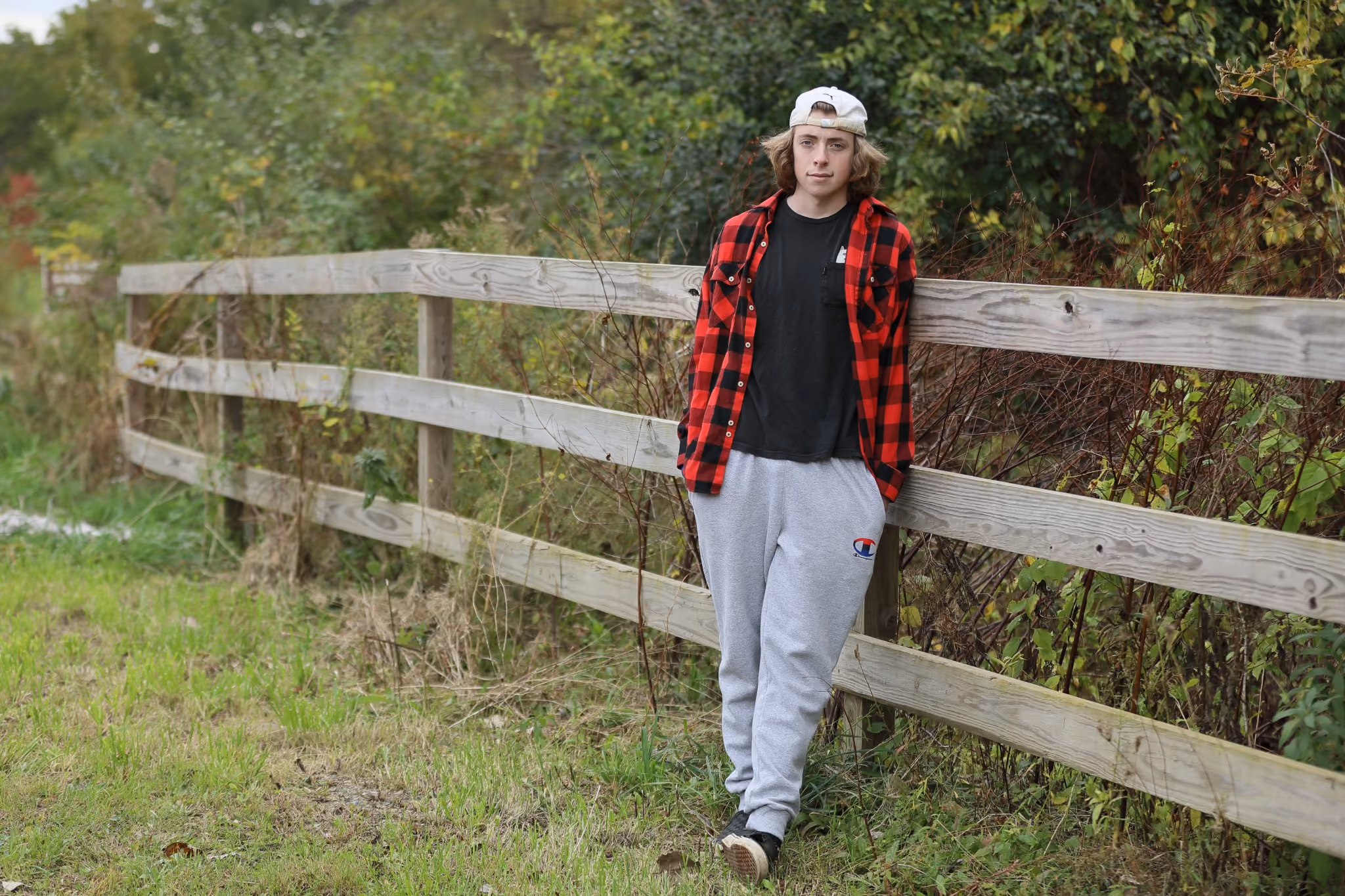 Portrait of a young man beside a wooden fence, photographed by Fullerton Photography.