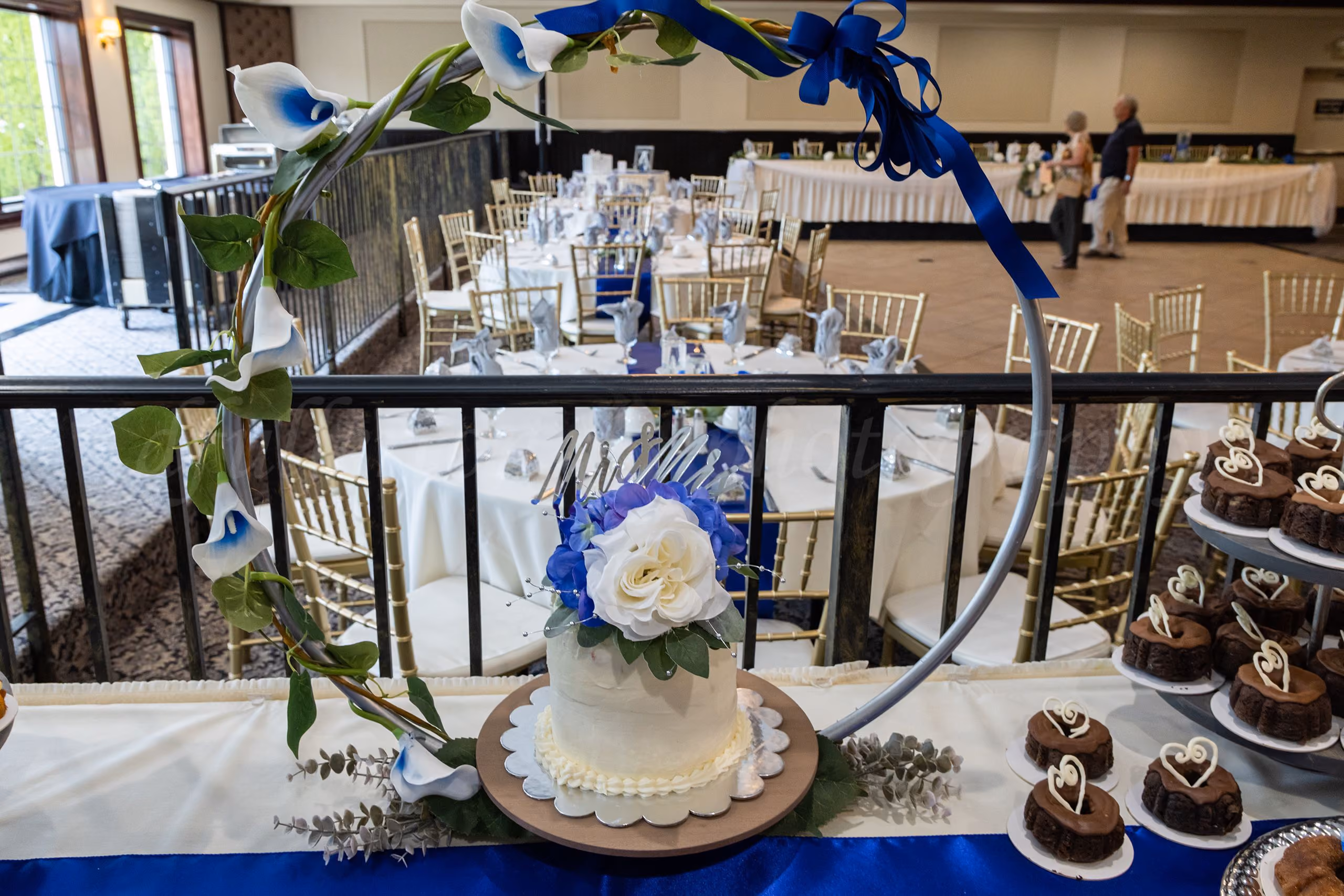 Wedding reception cake table with a floral hoop backdrop, blue and white decor, dessert tiers, photo by Fullerton Photography