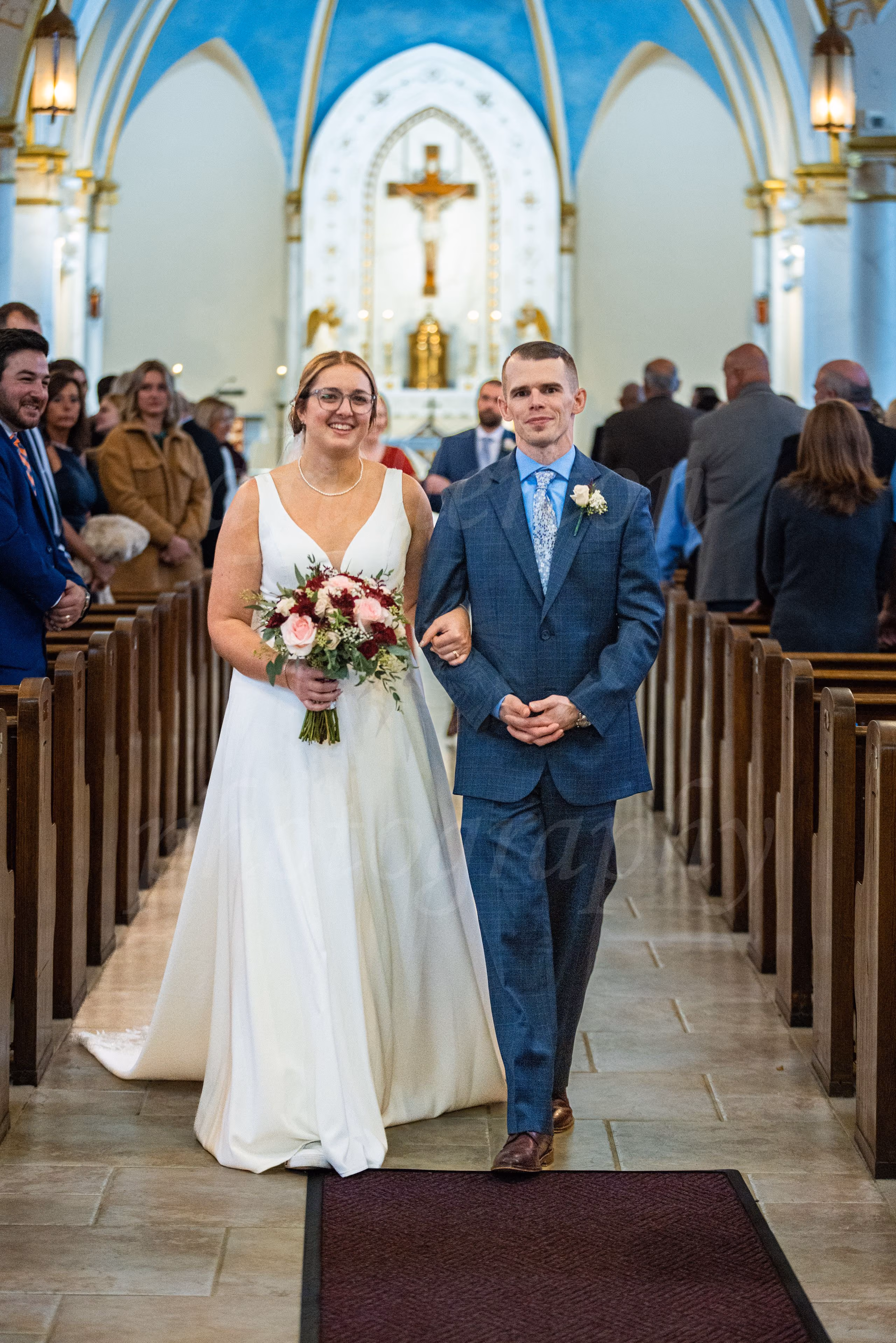 Bride and groom walking together back down the church aisle after their wedding ceremony