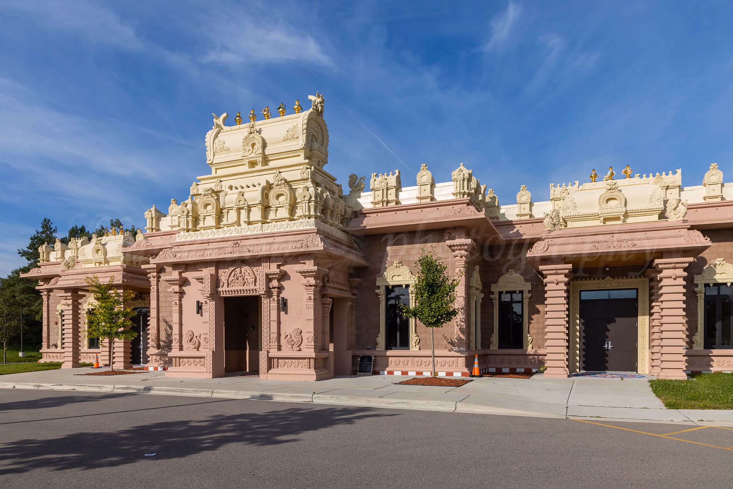 Exterior of an ornately carved Hindu temple with intricate stone architecture under a blue sky