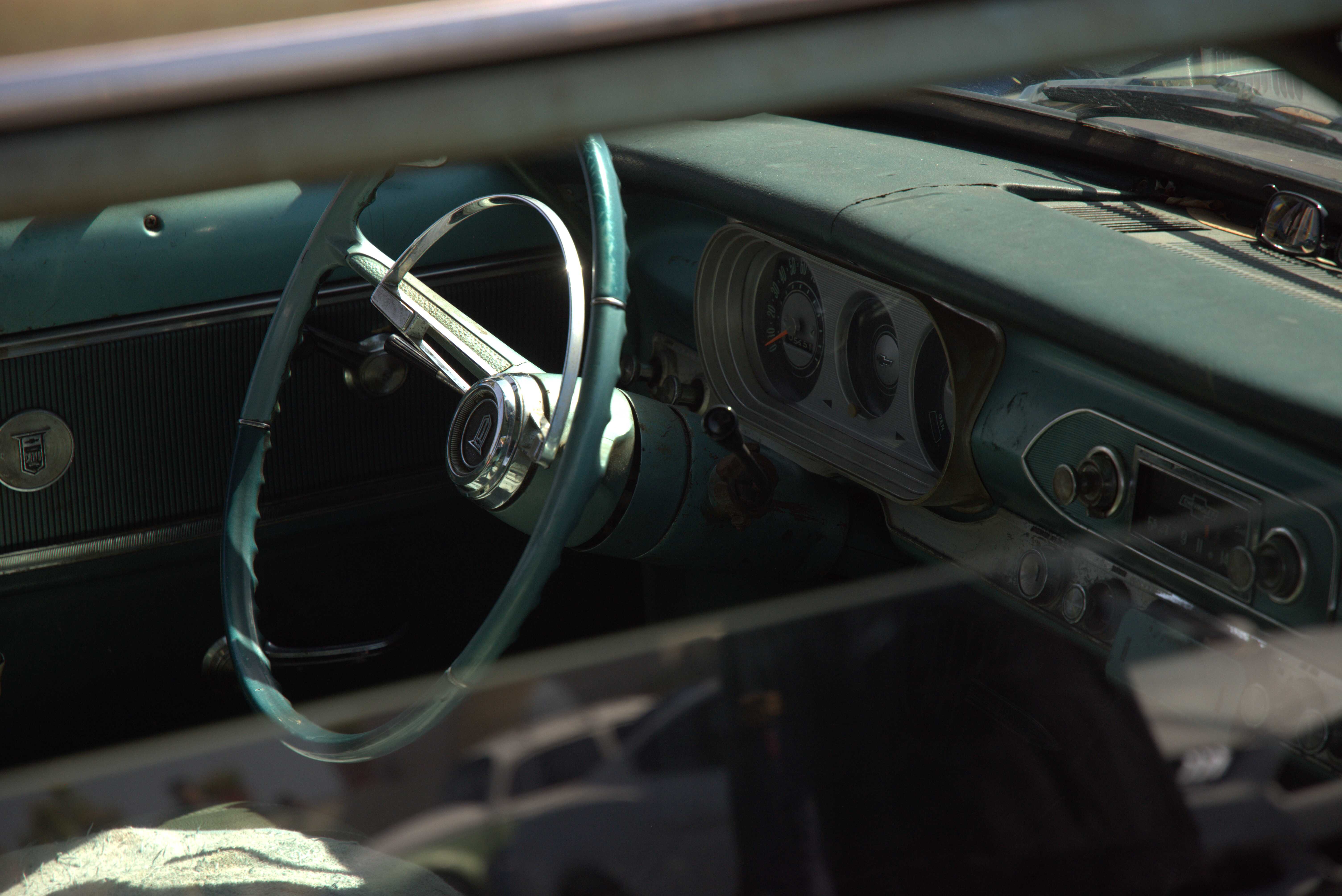 A photo of the interior of a classic car taken from the outside