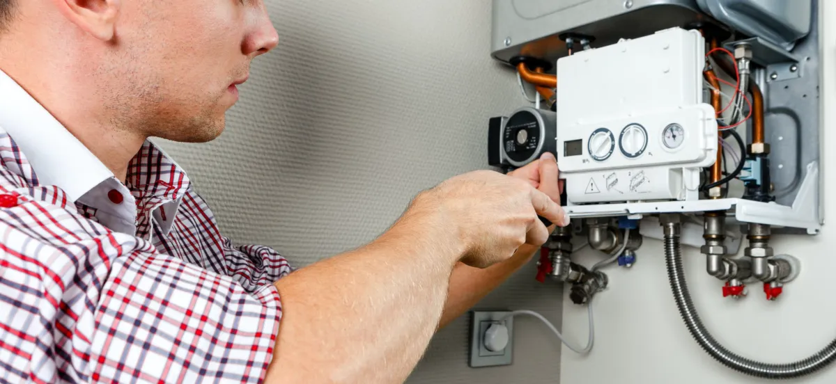 Technician servicing a wall-mounted water heater