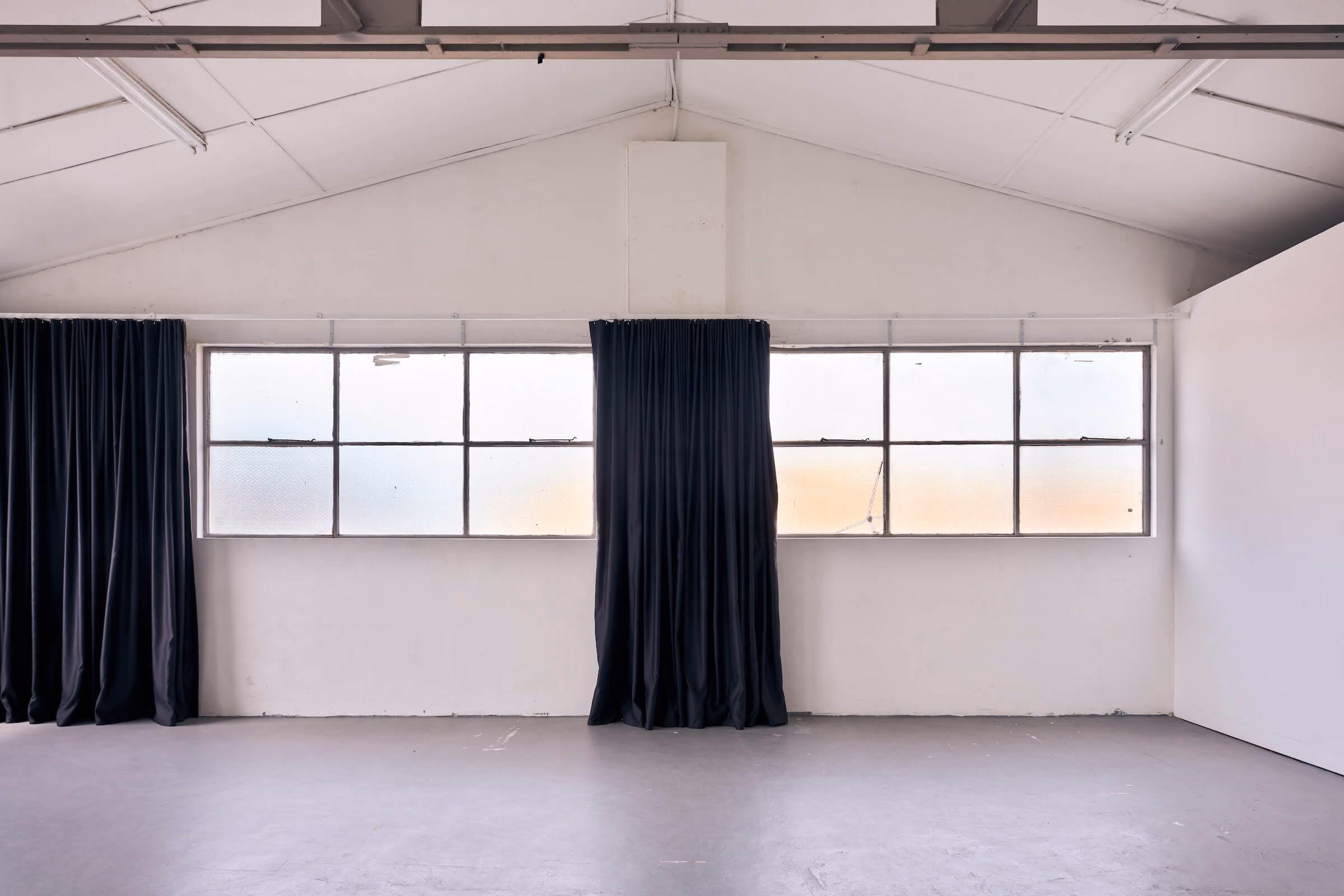 Big bright windows with curtains open in the large photography studio