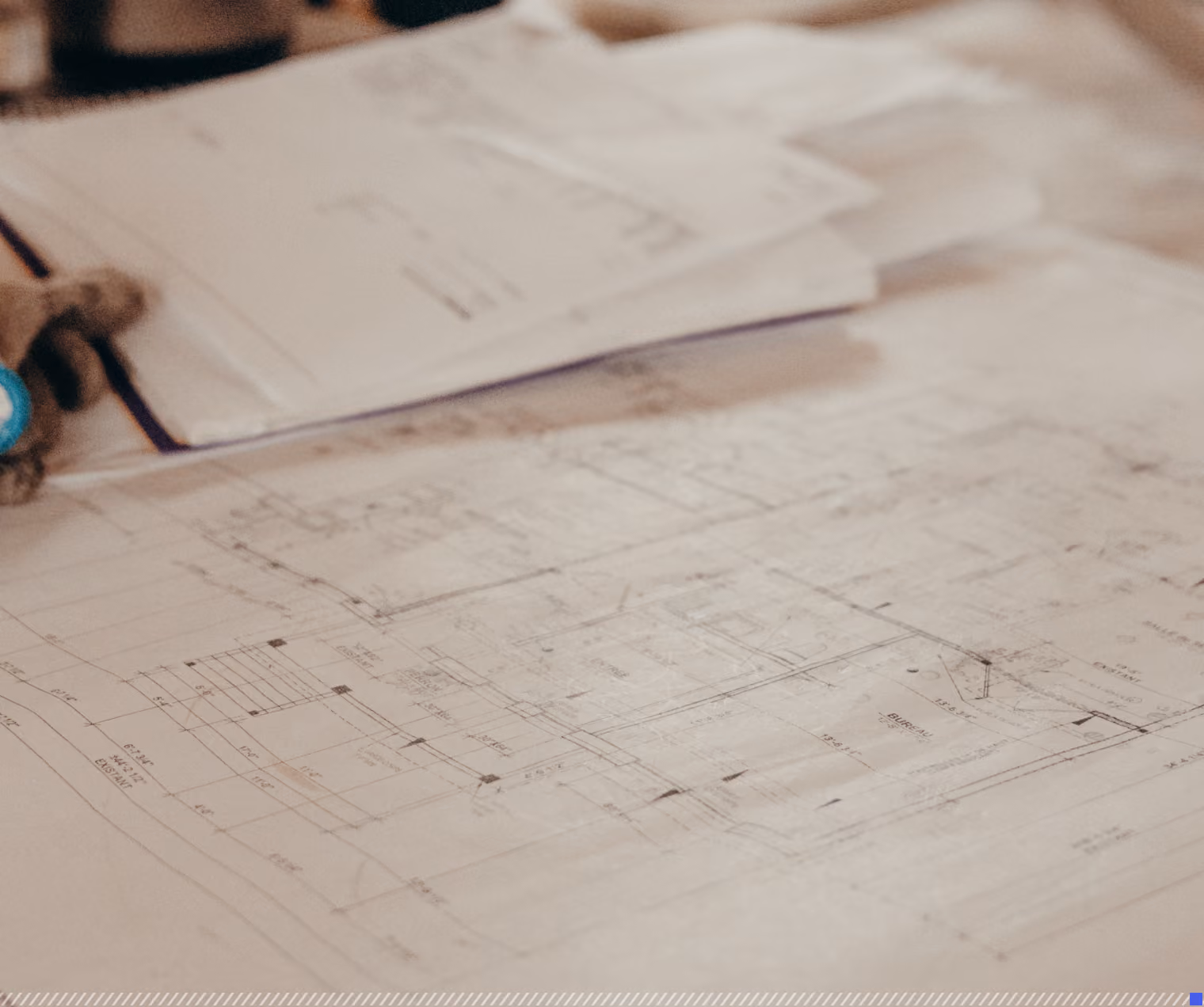 Architectural blueprints and technical drawings spread out on a table.