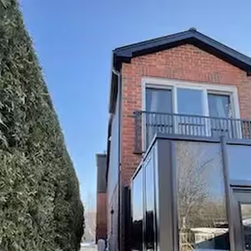 A brick home extension with black framed glazing