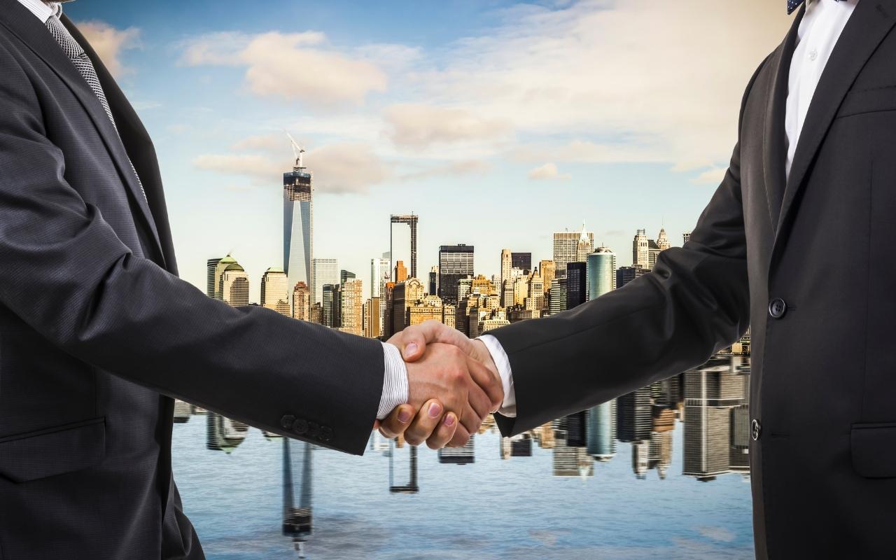 A handshake representing the MYOB and Kounta deal.