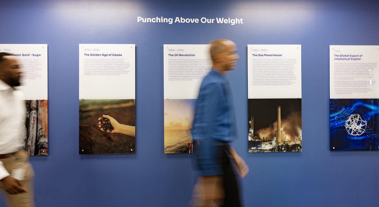 Punching Above Our Weight exhibition wall, its panels tracing Trinidad and Tobago's industrial history from sugar and cocoa to oil, gas and intellectual capital