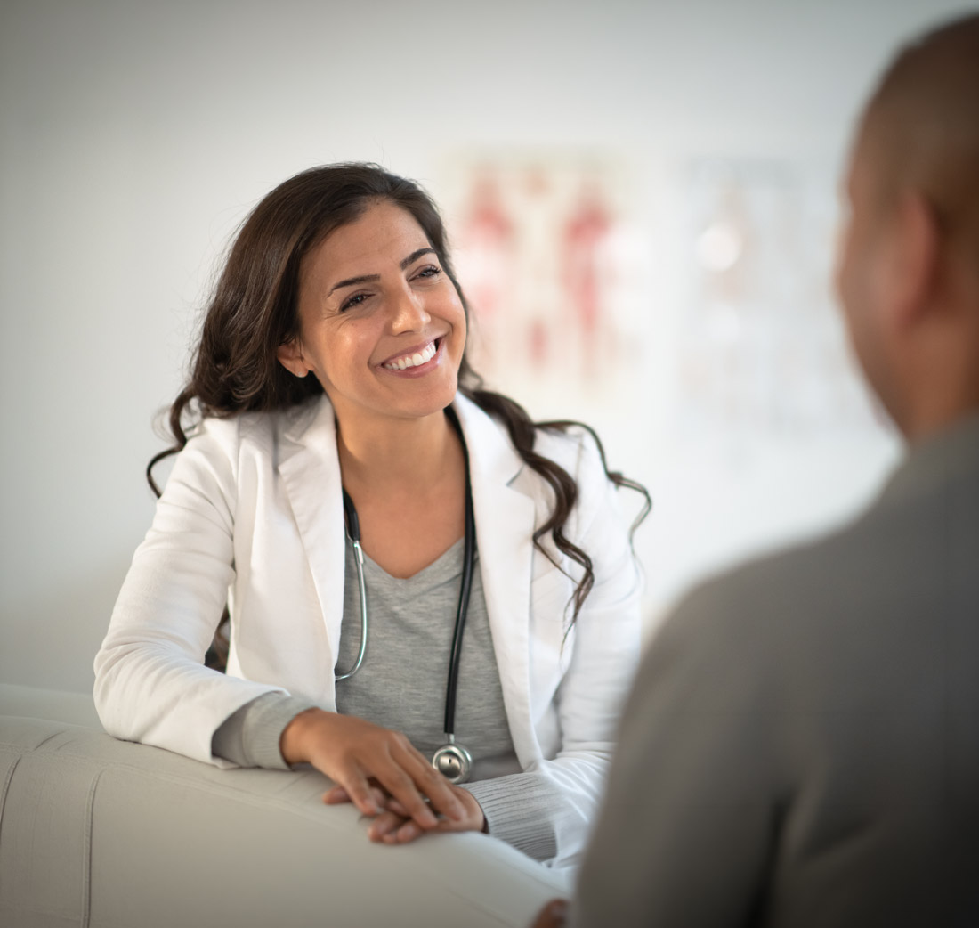 A composite image featuring a smiling female healthcare provider above a man in an orange jumpsuit working on a laptop, highlighting Hometown Health System's correctional care services.
