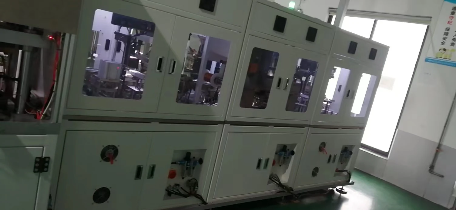 Alternate factory view of the original winding machines before redesign, showing observation windows, control areas and segmented sheet-metal panels.