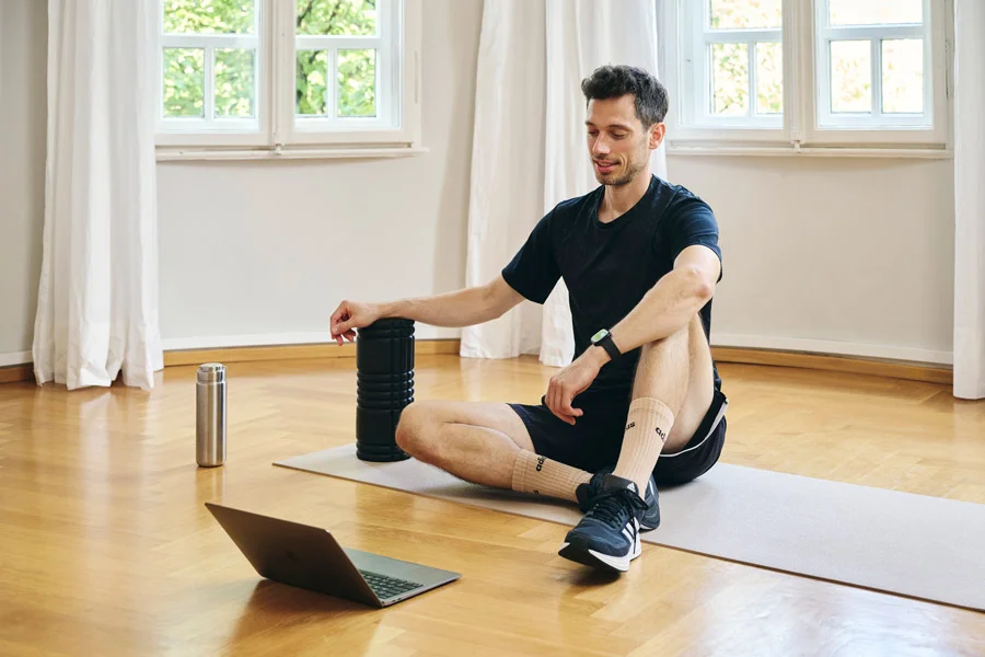 Lars Traxel bereitet mit Laptop und mobilem Equipment eine flexible Trainingseinheit für Berufstätige vor.