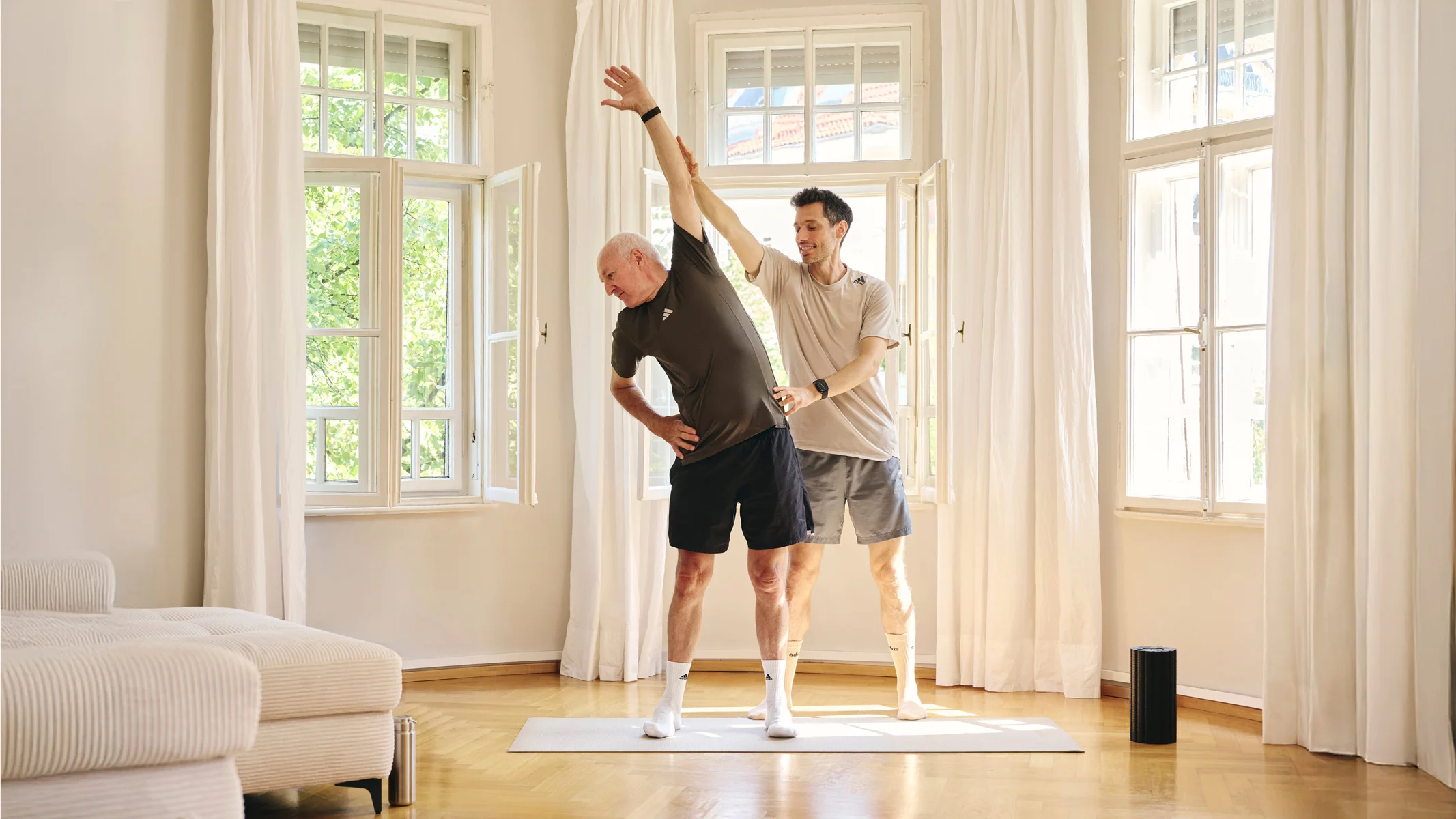 Lars Traxel begleitet einen Klienten beim funktionellen Personal Training zu Hause in München.