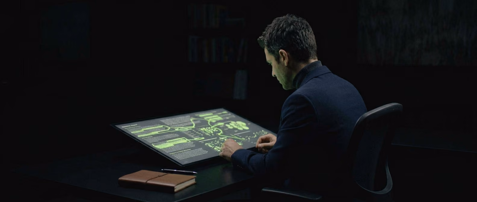 An analyst reviews a research report alone at a desk, lime-green highlights marking key findings on the glowing screen.