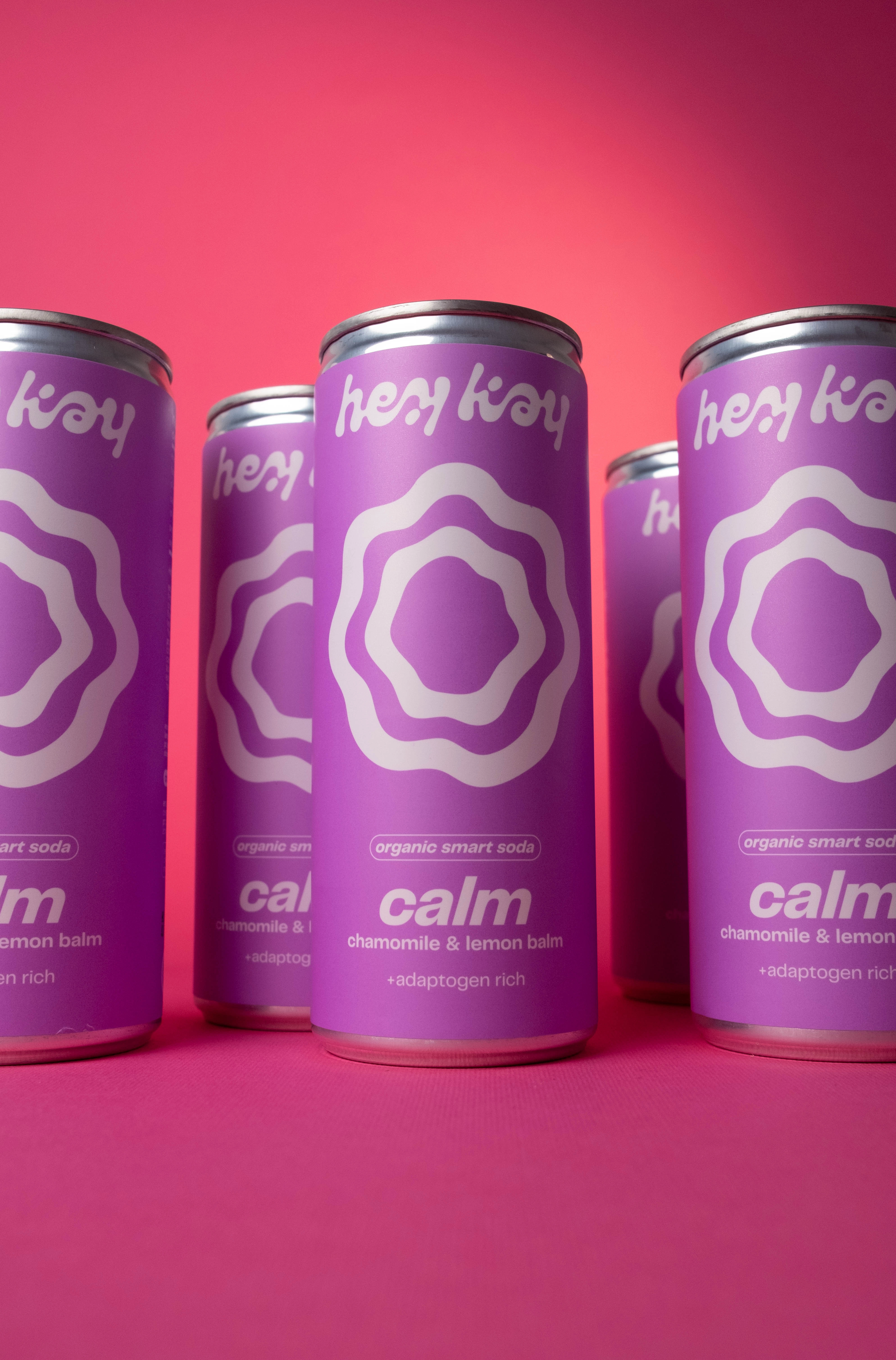 Latas de hey kay calm sobre fundo rosa