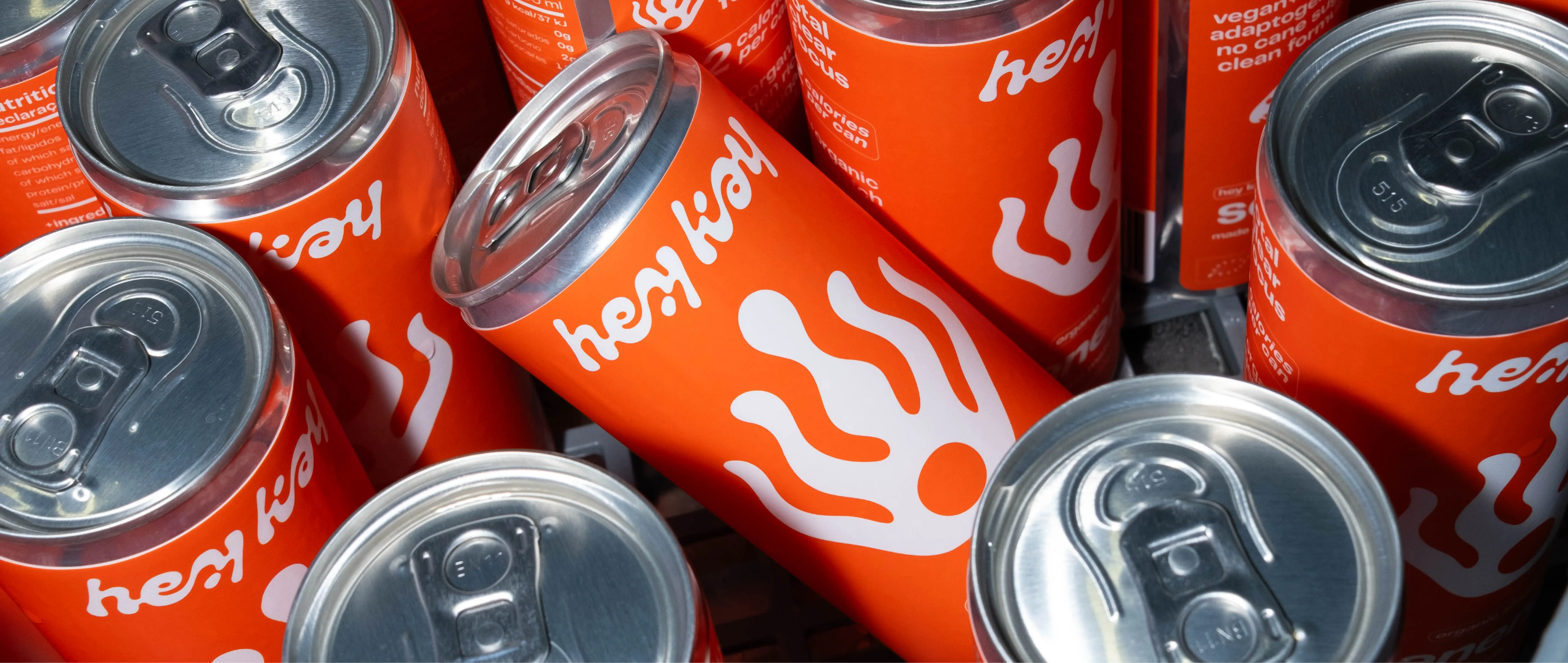 Lata de hey kay energy deitada entre outras latas