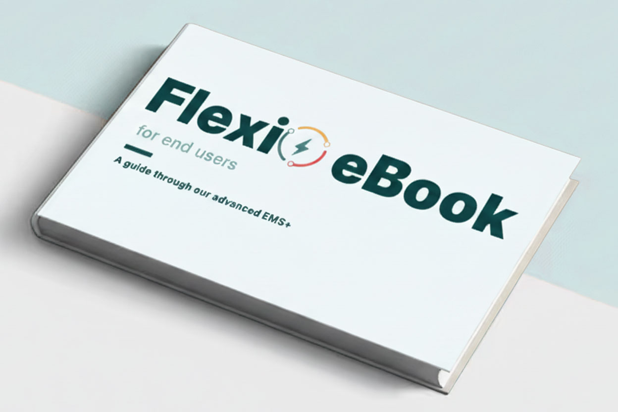 Closed white book titled 'FlexiO Book for end users' with a subtitle 'A guide through our advanced EMS+' on the cover.