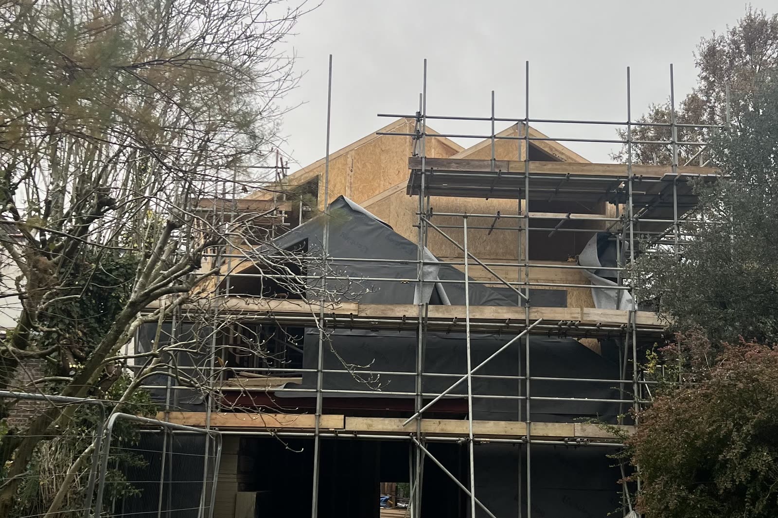 The house under scaffold seen from the garden, the roof being covered