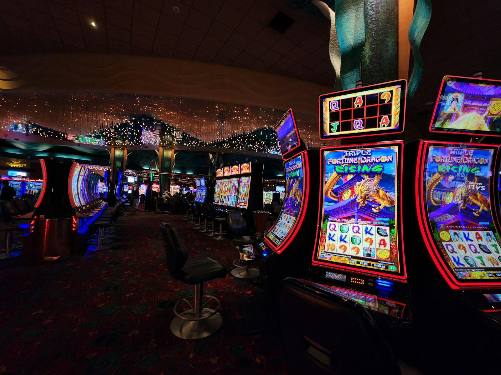 Casino floor lined with illuminated slot machines