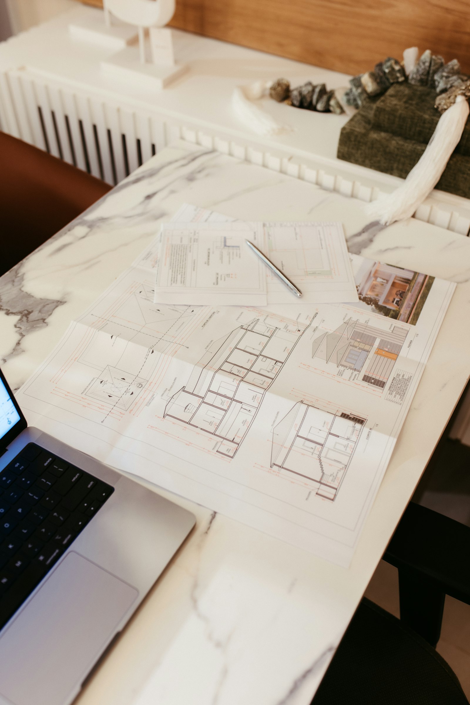 Construction drawings and a laptop on a desk | Westside Construction Group