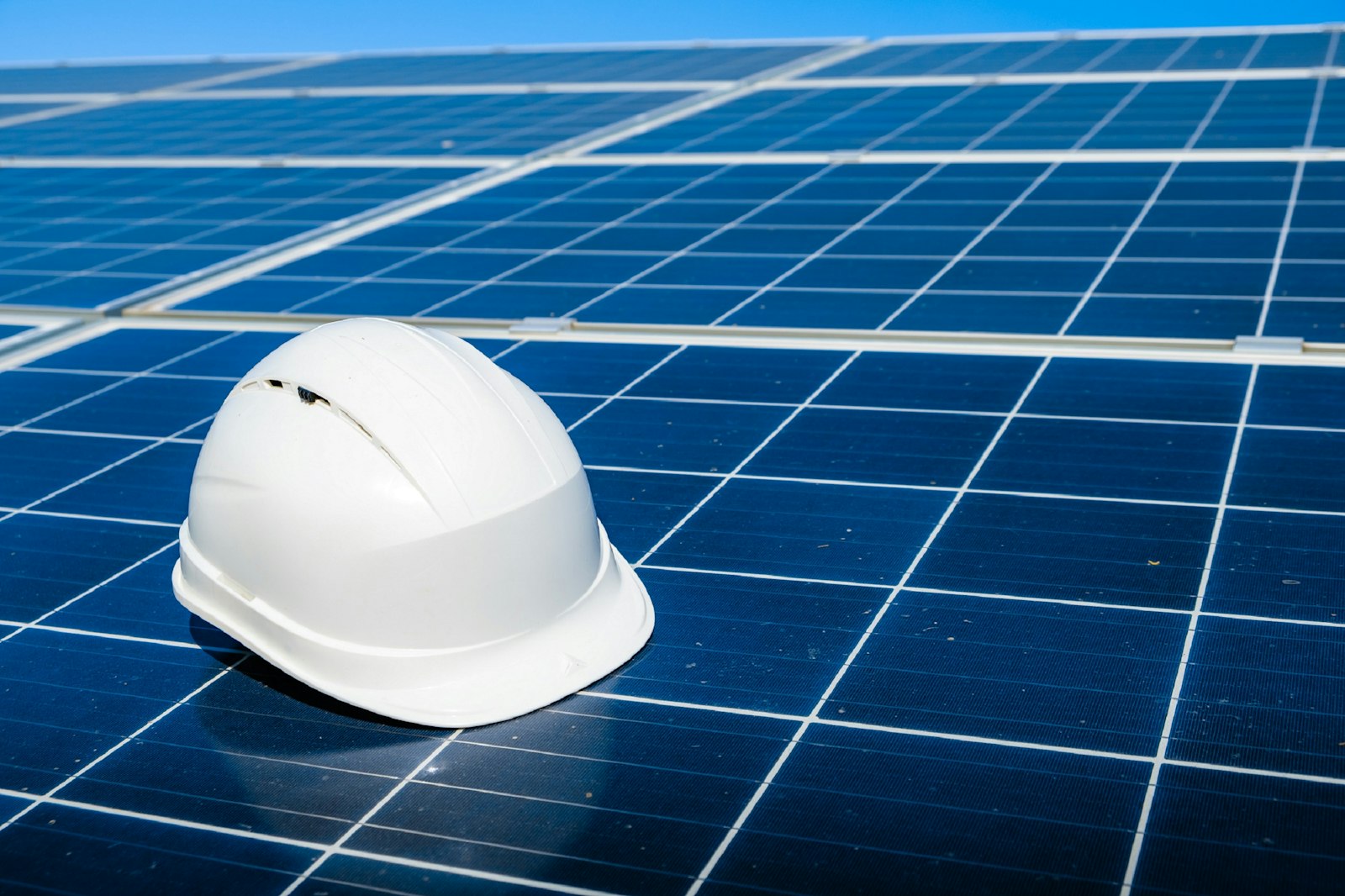 Hard hat resting on a solar panel | Westside Construction Group