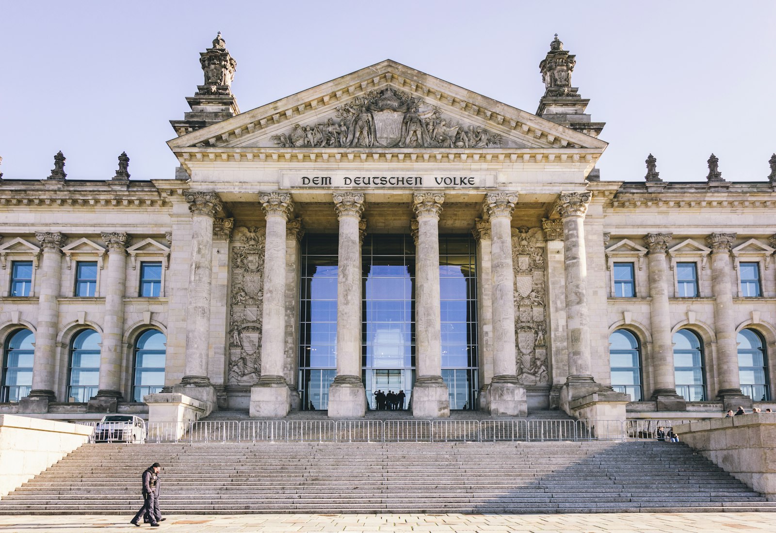 People walking past a government building | Westside Construction Group