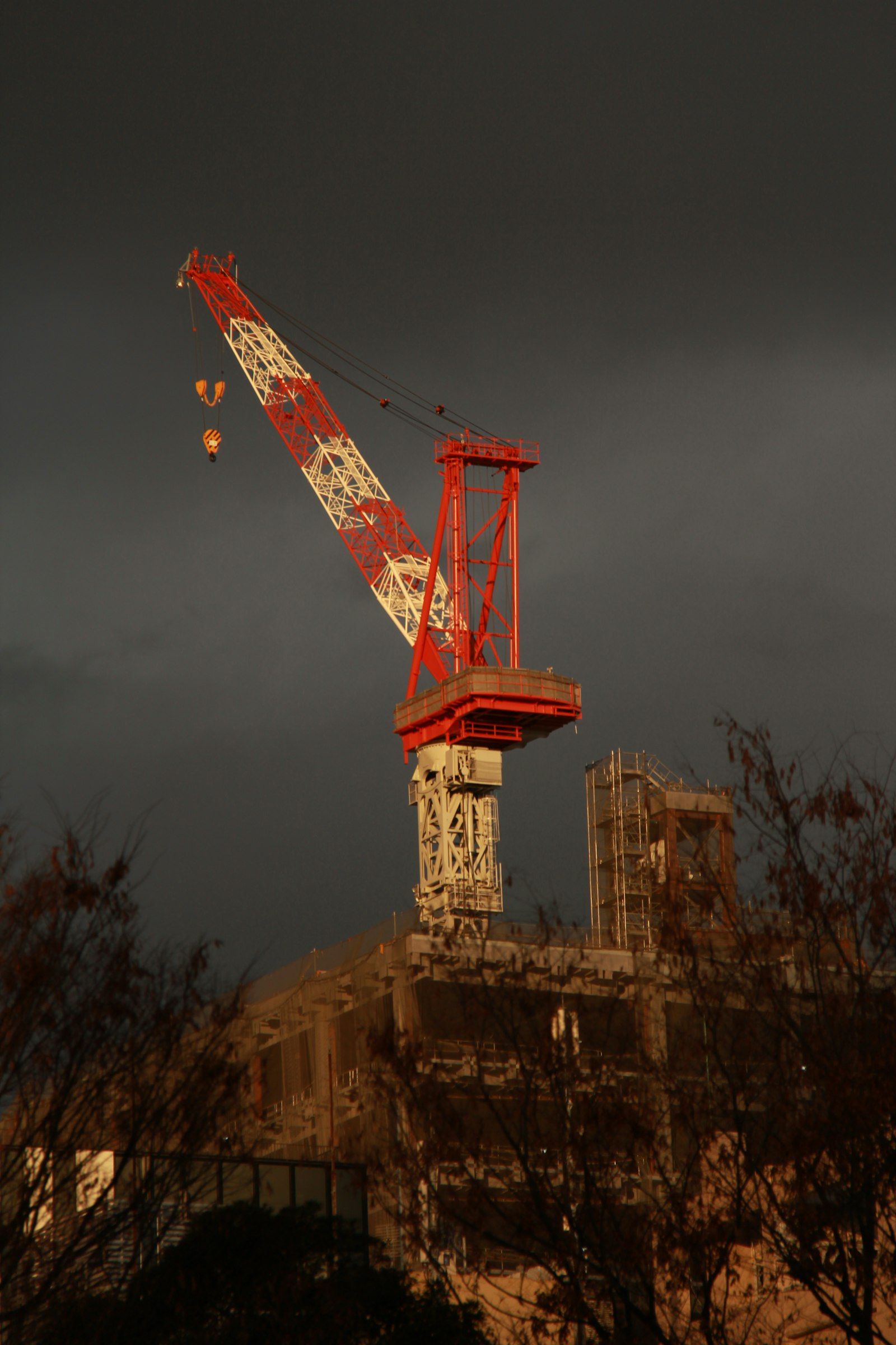 Stock photo of a large construction crane against a dark, cloudy sky, used to illustrate Hurricane Isaias warning coverage | Westside Construction Group