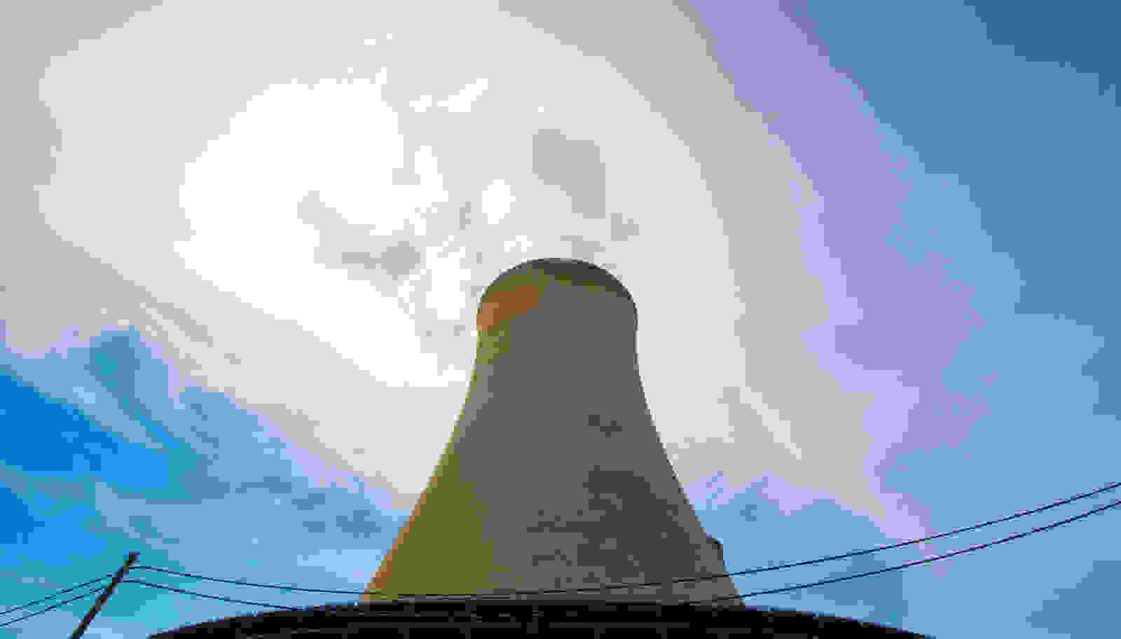 A nuclear plant cooling tower under blue sky, from Constellation's announcement of 890 MW of uprates backed by Google | Westside Construction Group