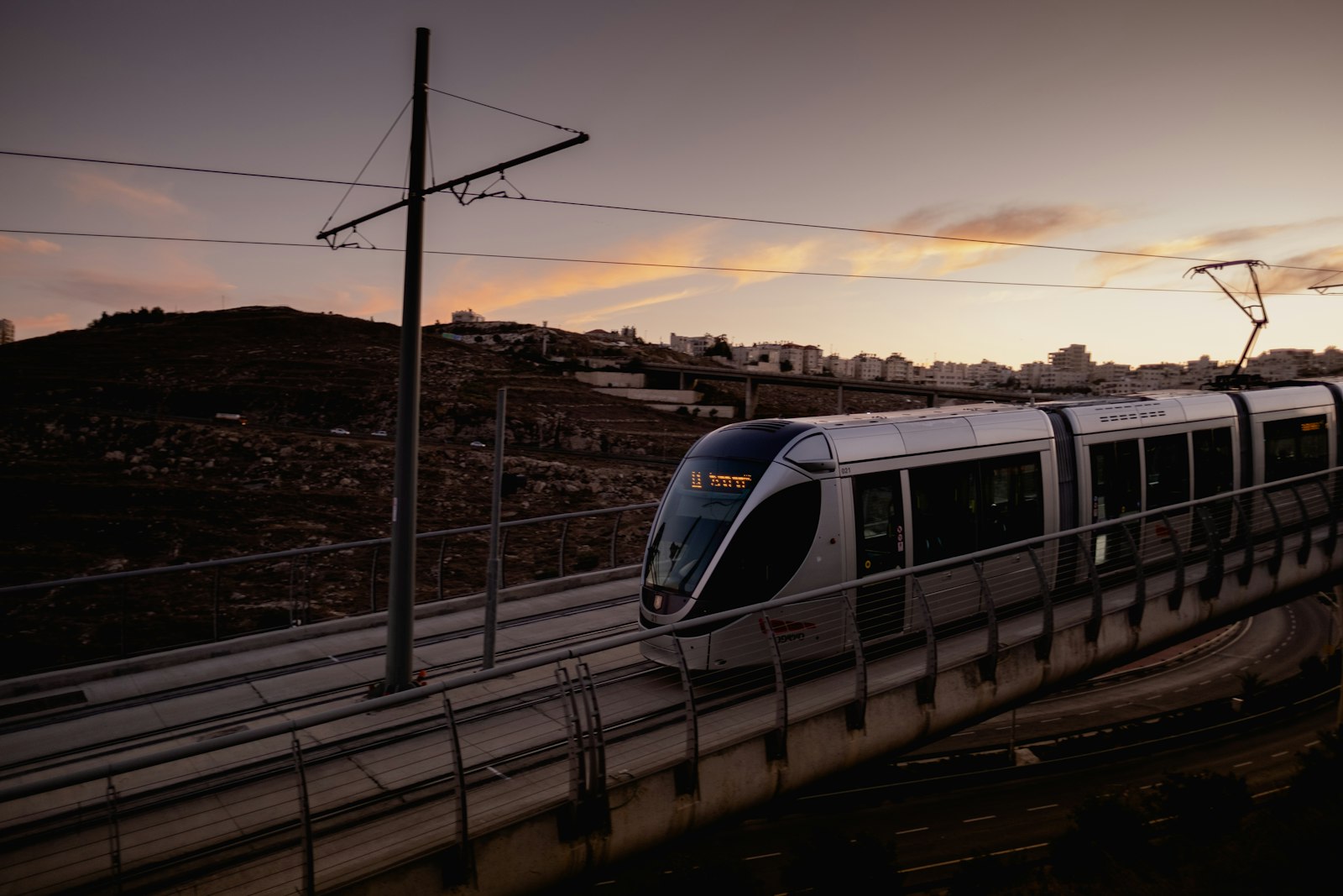 White and blue light rail train running on tracks during the day | Westside Construction Group